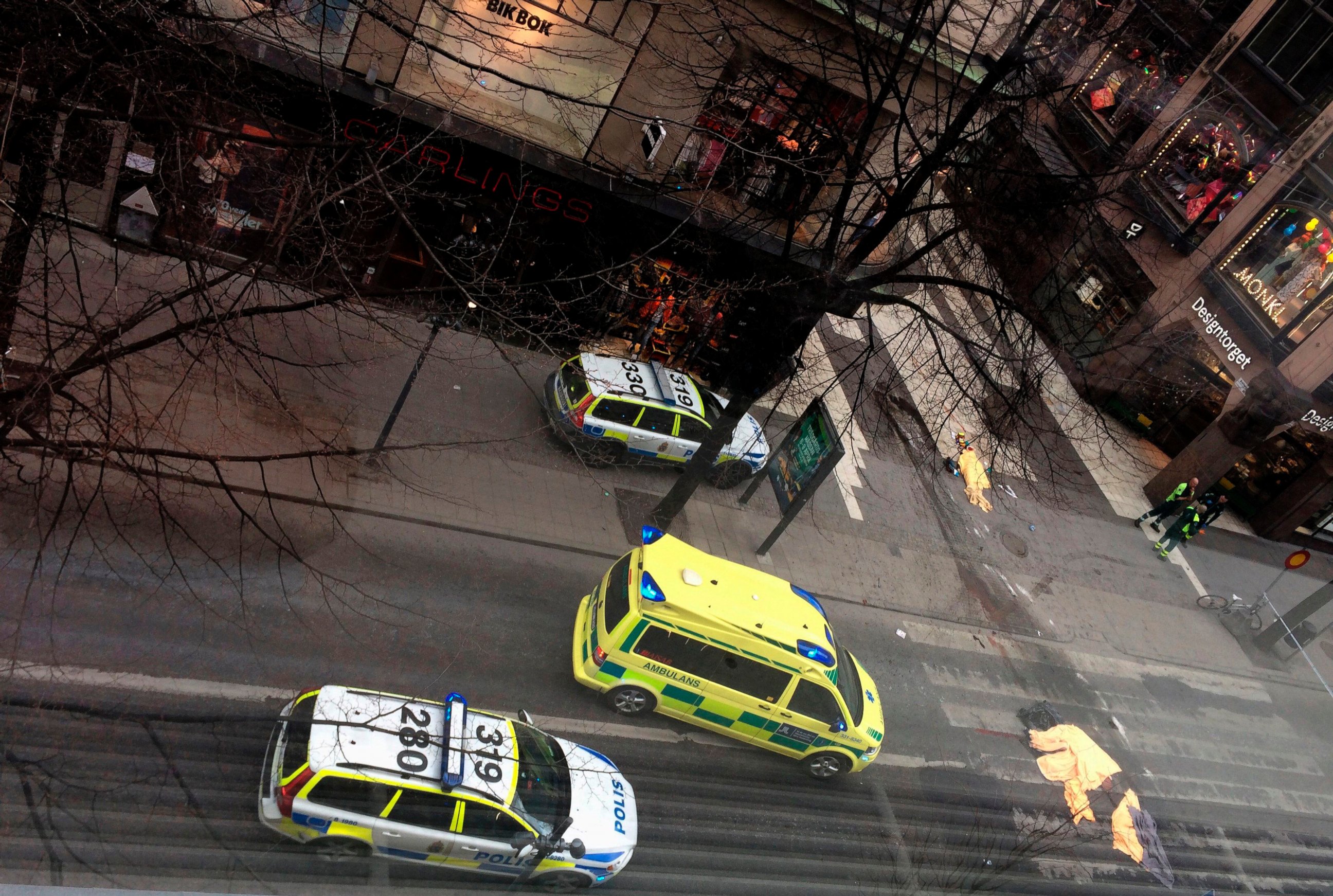 PHOTO: An ambulance stands near covered bodies at the scene where a truck crashed into the Ahlens department store at Drottninggatan in central Stockholm, April 7, 2017.