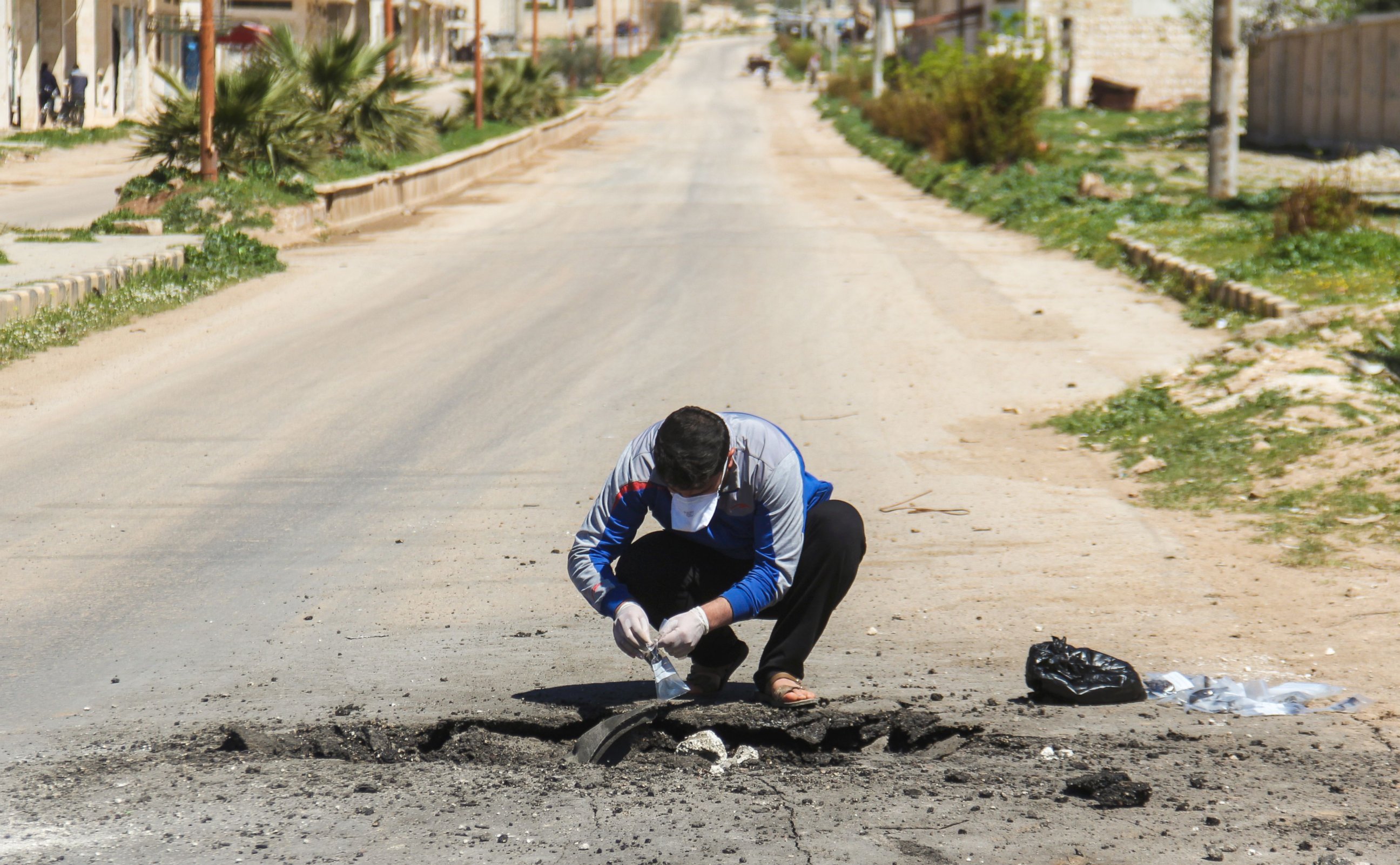 PHOTO: A Syrian man collects samples from the site of a suspected toxic gas attack in Khan Sheikhun, in Syria's Idlib province, April 5, 2017.
