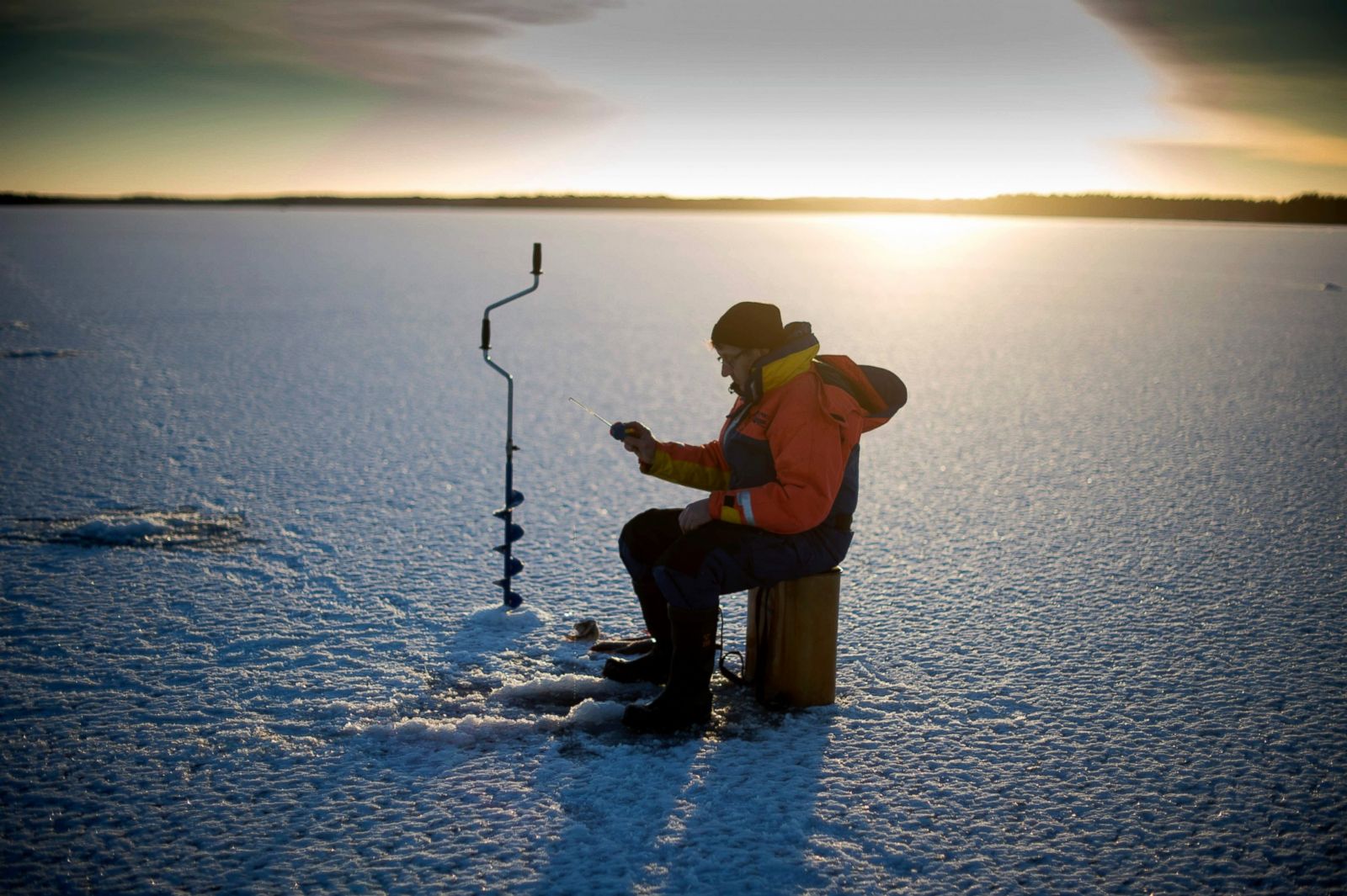 A man is ice-fishing at midday on the frozen Bothnia Sea, Dec. 