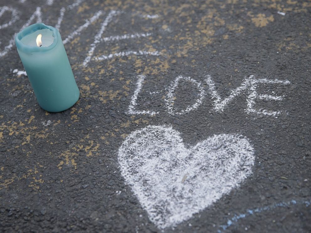 PHOTO: A candle burns next to a heart drawing at a makeshift memorial at Place de la Bourse following attacks in Brussels, March 22, 2016.