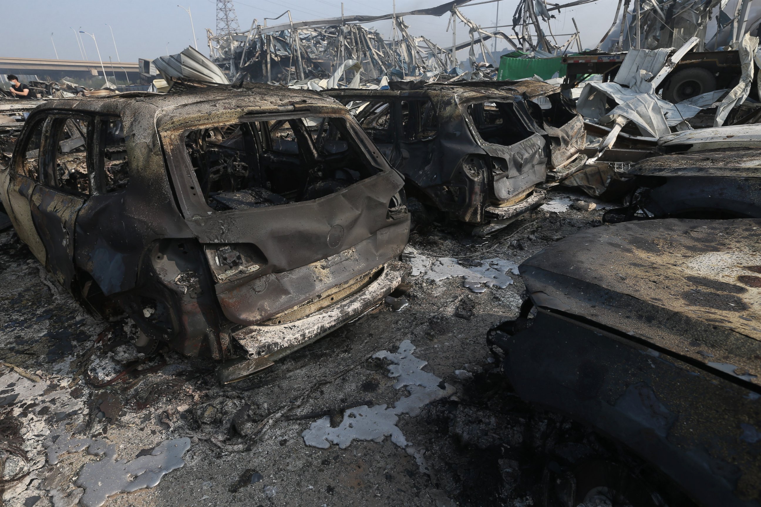 PHOTO: Burnt cars are seen in the debris following the explosions of a warehouse in Binhai New Area on Aug. 13, 2015 in Tianjin, China. 