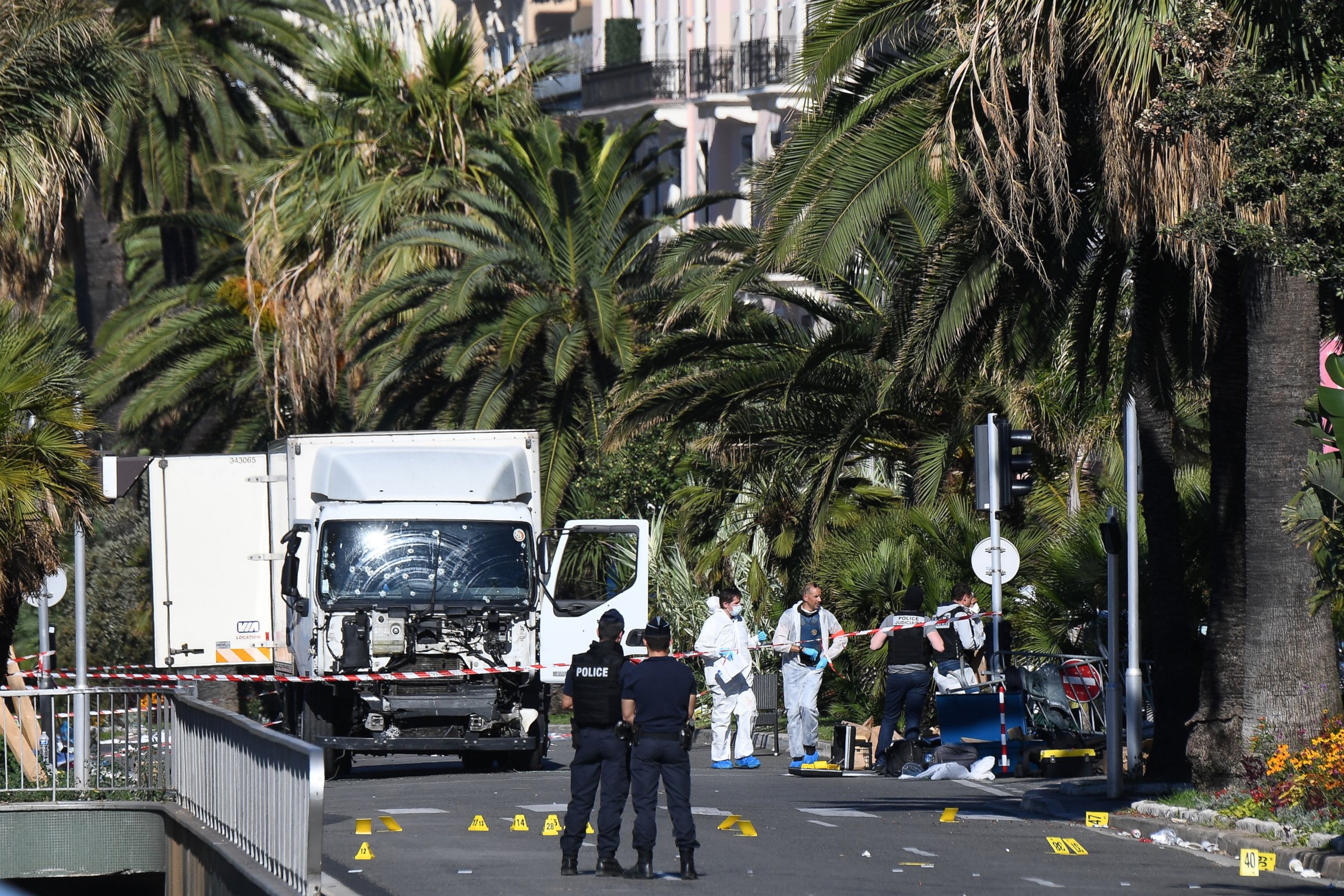 PHOTO: Forensics officers and policemen look for evidence near a truck on the Promenade des Anglais seafront in the French Riviera town of Nice on July 15, 2016, after it drove into a crowd watching a fireworks display.