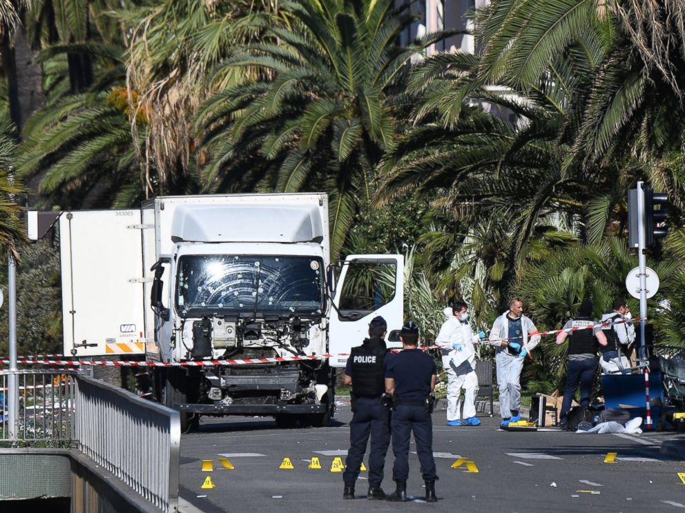 PHOTO: Forensics officers and policemen look for evidence near a truck on the Promenade des Anglais seafront in the French Riviera town of Nice on July 15, 2016, after it drove into a crowd watching a fireworks display.