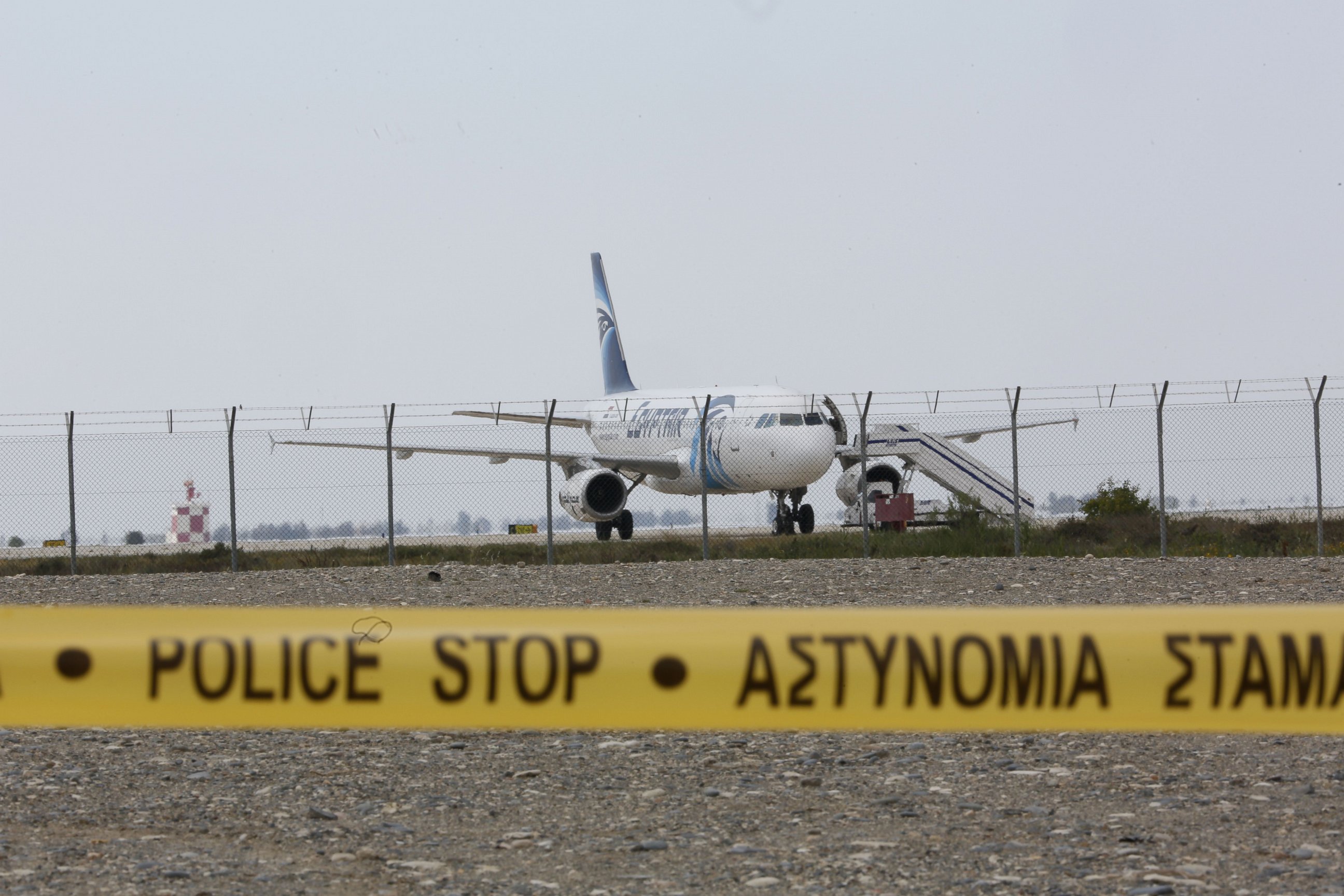 PHOTO:Cypriot security forces cordon off the area around Larnaca airport where an EgyptAir Airbus A-320 is seen on the tarmac after being hijacked and diverted to Cyprus, March 29, 2016. 