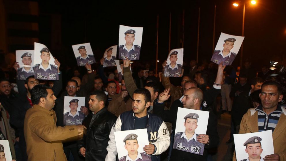 Protestors carry pictures of Mu'ath al-Kaseasbeh, Jordanian pilot who crashed in Syria, at a protest near the Jordanian Prime Minister office in Amman, Jordan, Jan. 27, 2015.