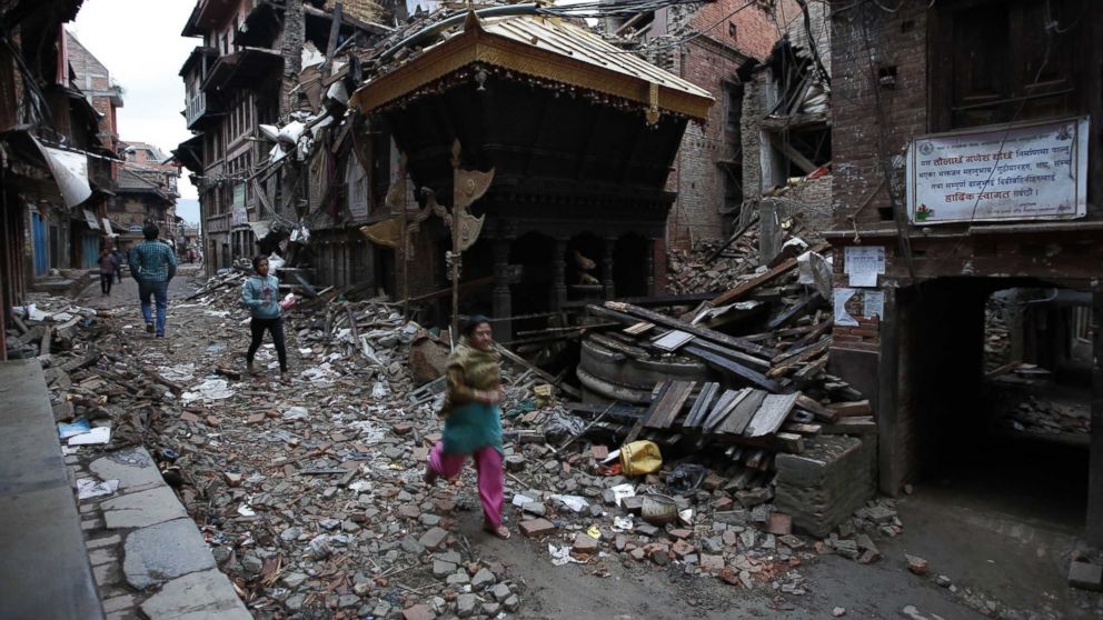 People walk among the debris of houses after a powerful earthquake hits Bhaktapur, Nepal, April 27, 2015.