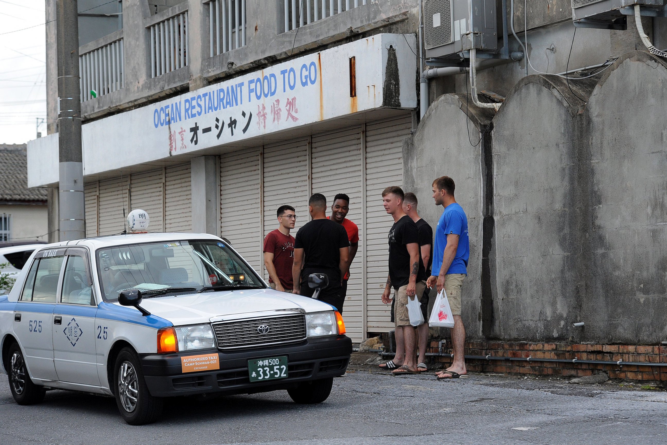 PHOTO: Marines from nearby Camp Schwab arrive by taxi at a sushi Restaurant in Henoko, Okinawa, where most of the restaurant's business comes from military customers. 