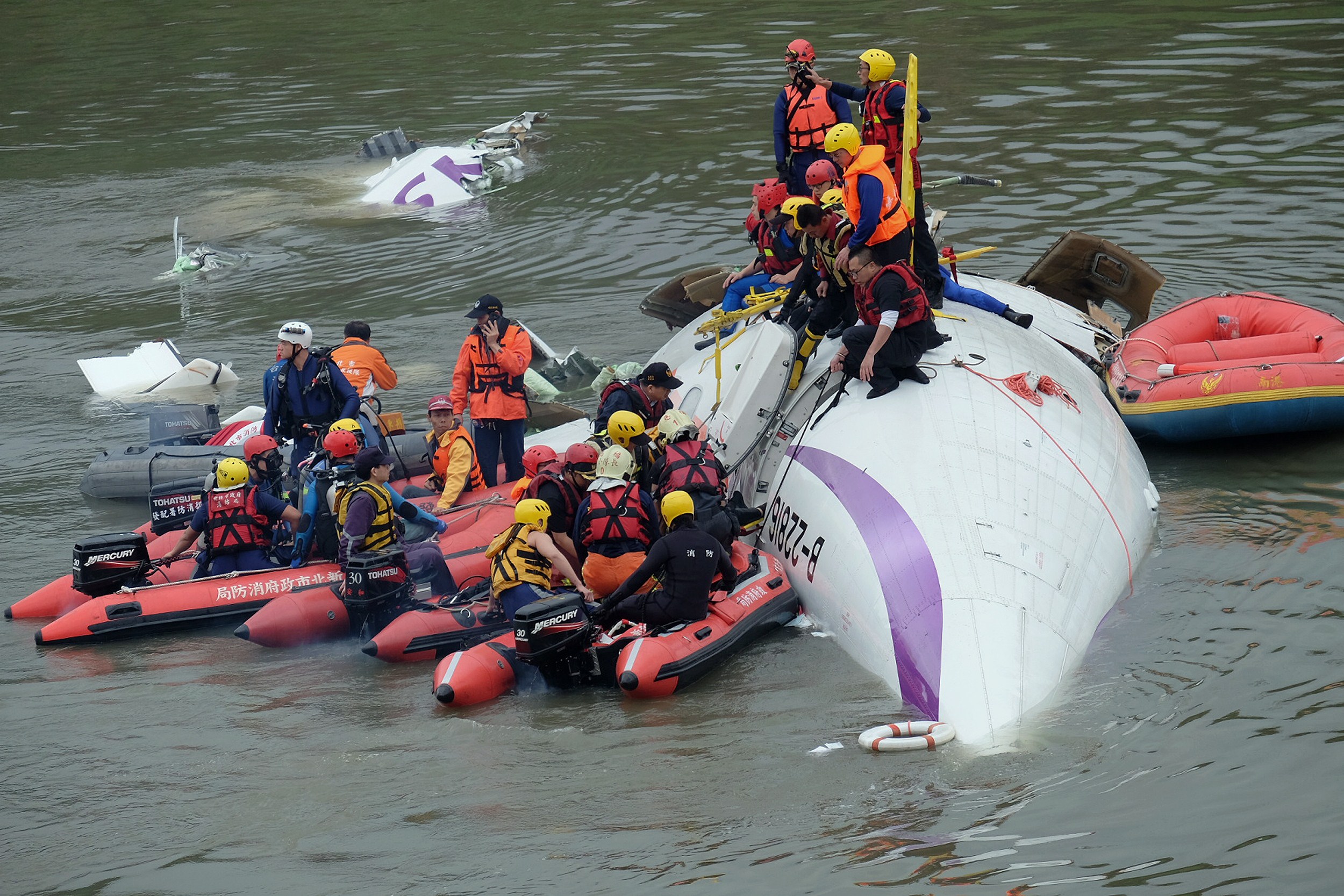 PHOTO: Rescue personnel work to free passengers from a TransAsia ATR 72-600 turboprop plane that crash-landed into a river outside Taiwan's capital Taipei in New Taipei City, February 4, 2015.