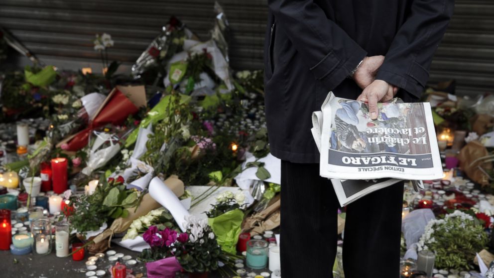 Flowers and candles are placed outside the La Belle Equipe restaurant along the Rue de Charonne in central east Paris, on November 15, 2015, two days after deadly attacks across the city. Islamic State jihadists claimed a series of coordinated attacks by gunmen and suicide bombers in Paris that killed at least 128 people in scenes of carnage at a concert hall, restaurants and the national stadium.