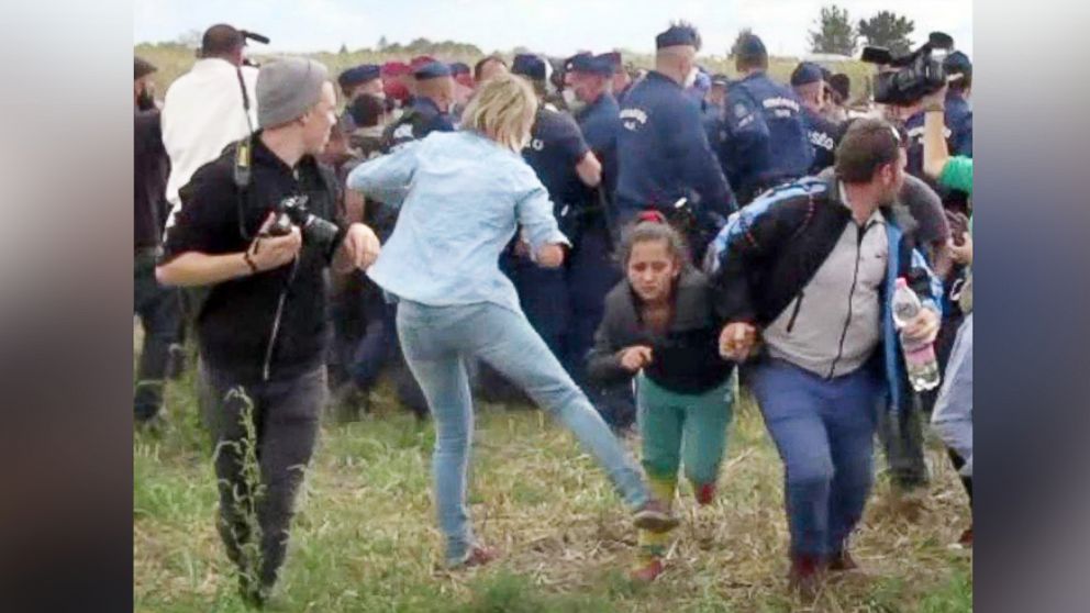 This video grab made on Sept. 9, 2015 shows a Hungarian TV camerawoman kicking a child as she runs with other migrants from a police line during disturbances at Roszke, Hungary. 