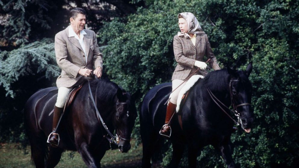 The queen rides with President Ronald Reagan on the grounds of Windsor Castle during his state visit on June 8, 1982.