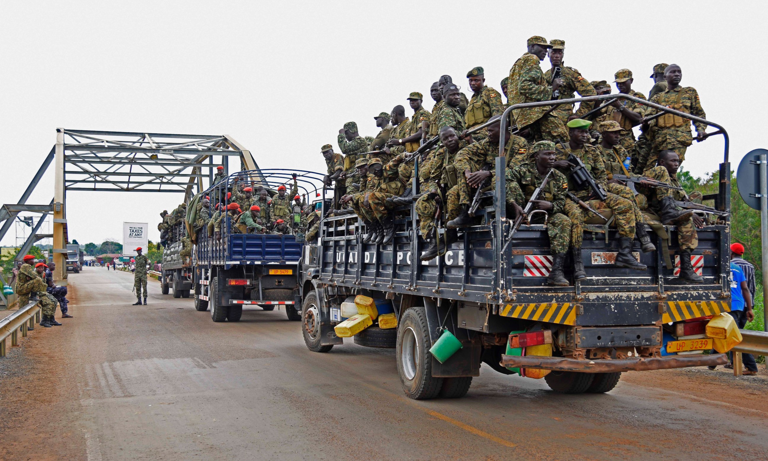 PHOTO: Uganda military personnel are seen atop military and police trucks as they drive towards Juba in South Sudan at Nimule border point, on July 14, 2016. 