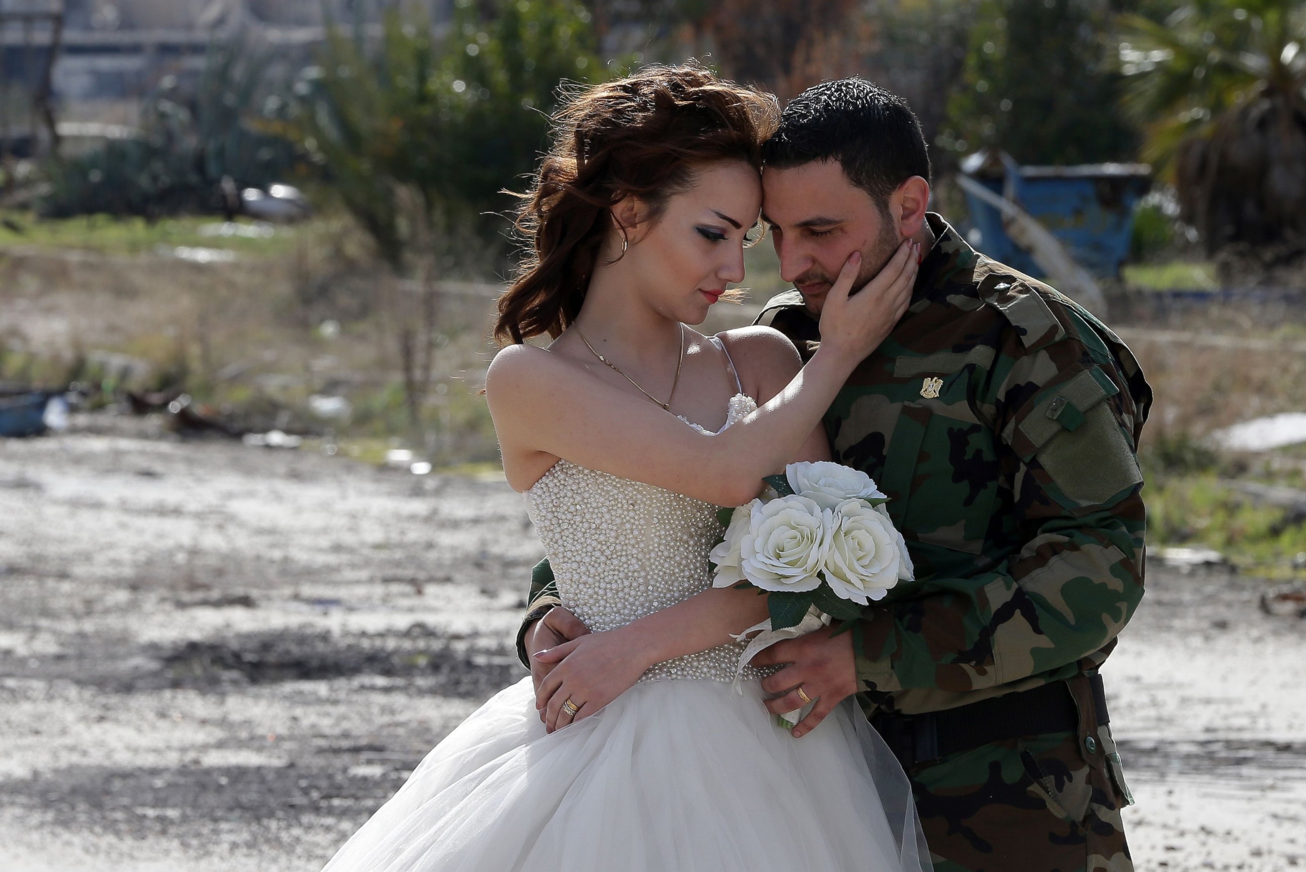 Newly-wed Syrian couple Nada Merhi, and Syrian army soldier Hassan Youssef, pose for a wedding picture amid heavily damaged buildings in the war ravaged city of Homs on Feb. 5, 2016.