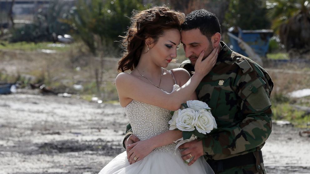 Newly-wed Syrian couple Nada Merhi, and Syrian army soldier Hassan Youssef, pose for a wedding picture amid heavily damaged buildings in the war ravaged city of Homs on Feb. 5, 2016.