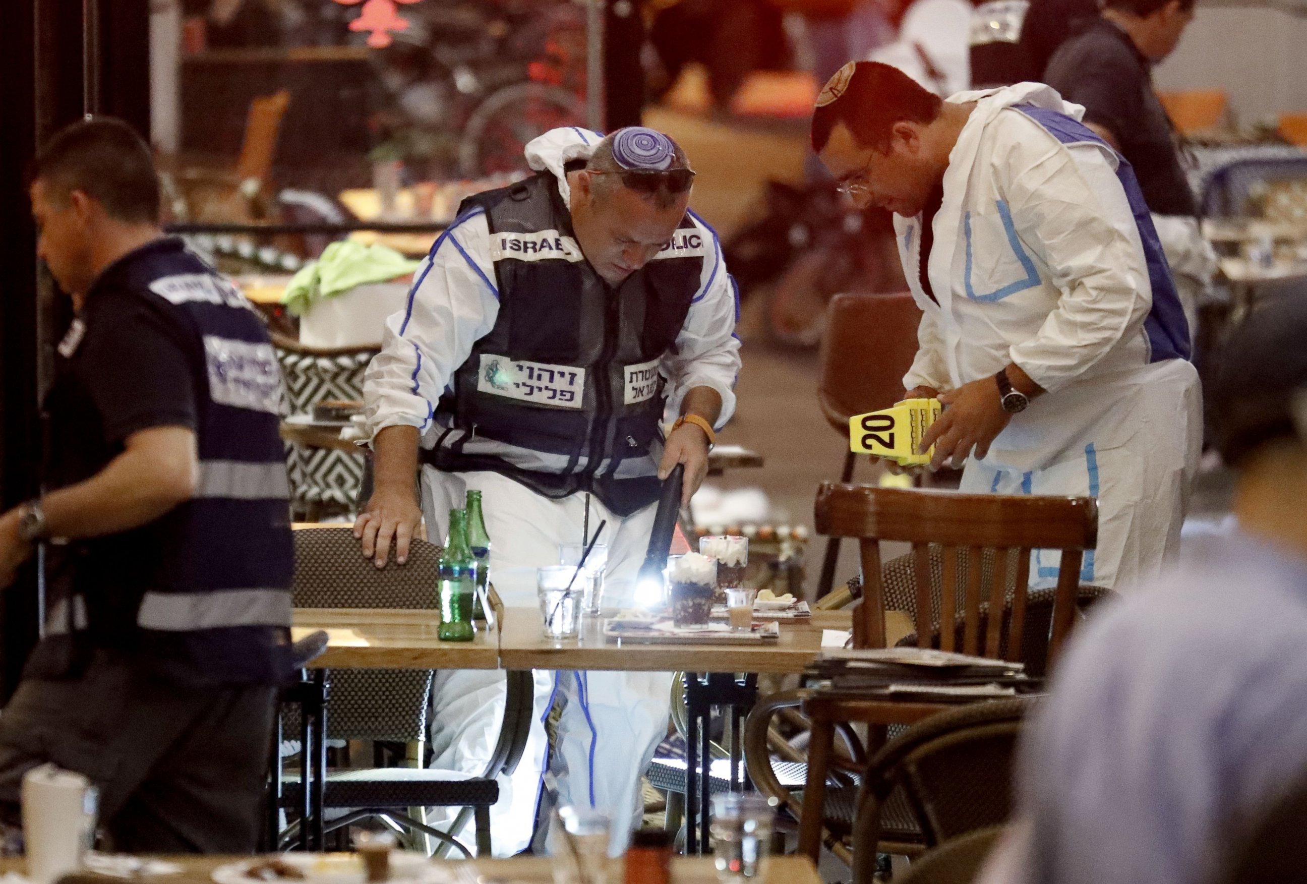 PHOTO: Israeli forensic police investigating the scene of a shooting at a shopping complex in the city of Tel Aviv on June 8, 2016. At least three people were killed and several wounded in the shooting spree, emergency services said. 