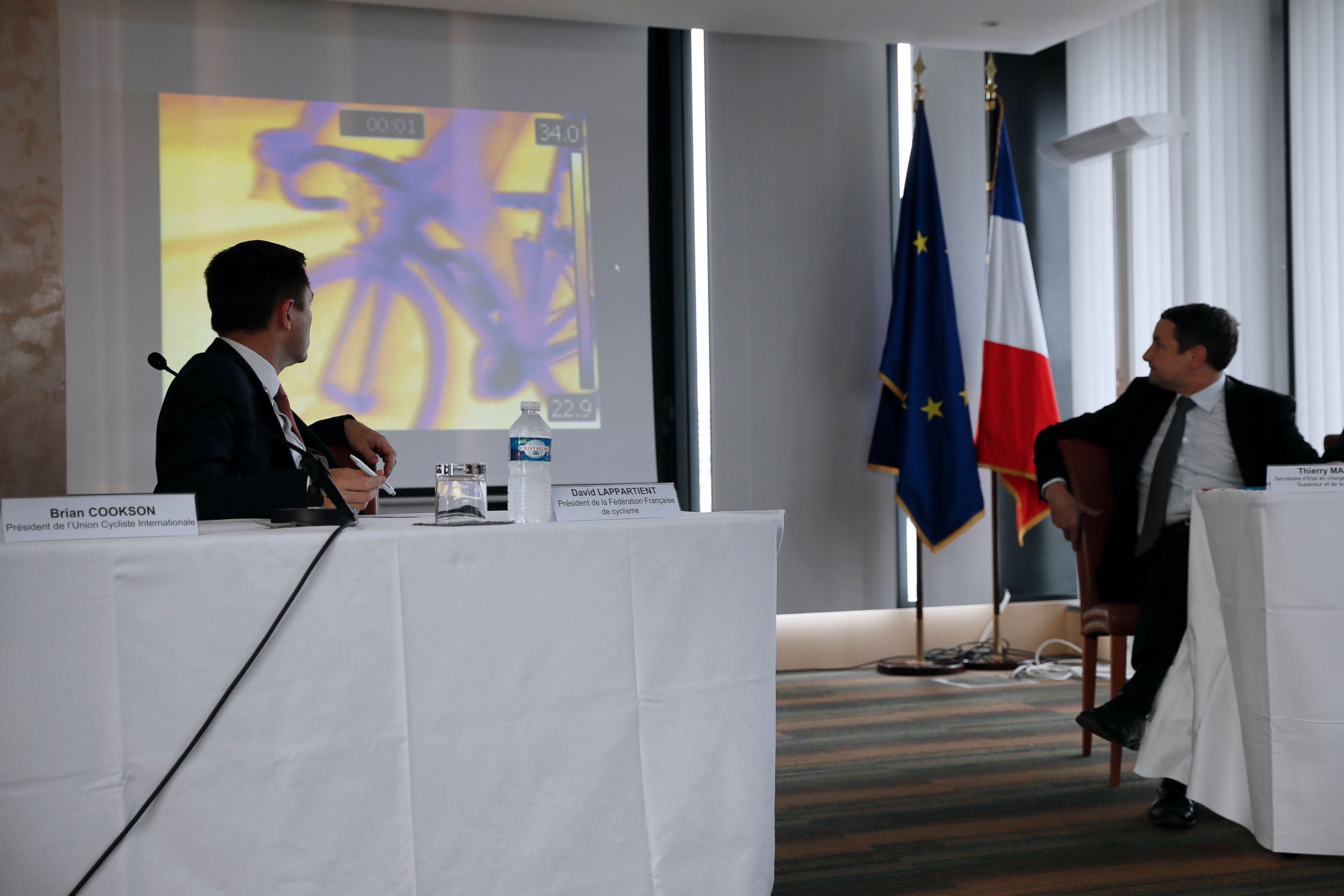PHOTO: President of the French cycling federation David Lappartient (L) and French Minister for Higher Education and Research Thierry Mandon (R) look at a screen during a press conference on mechanical fraud, on June 27, 2016. 