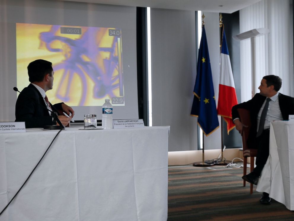 PHOTO: President of the French cycling federation David Lappartient (L) and French Minister for Higher Education and Research Thierry Mandon (R) look at a screen during a press conference on mechanical fraud, on June 27, 2016.