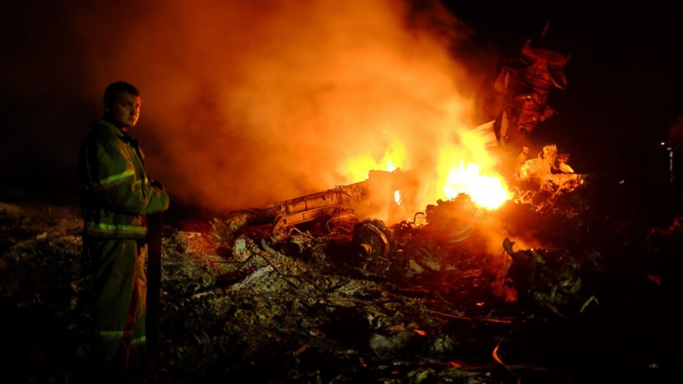 A firefighter stands as flames burst amongst the wreckages of the Malaysia airliner carrying 298 people from Amsterdam to Kuala Lumpur after it crashed, near the town of Shaktarsk, in rebel-held east Ukraine, on July 17, 2014.