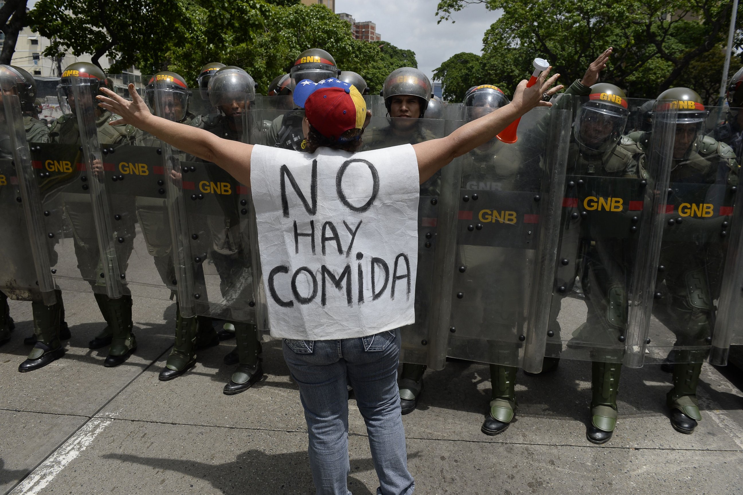 PHOTO: A woman with a sign reading "There is no food" protests against new emergency powers decreed this week by President Nicolas Maduro in front of a line of policemen in Caracas, on May 18, 2016. 