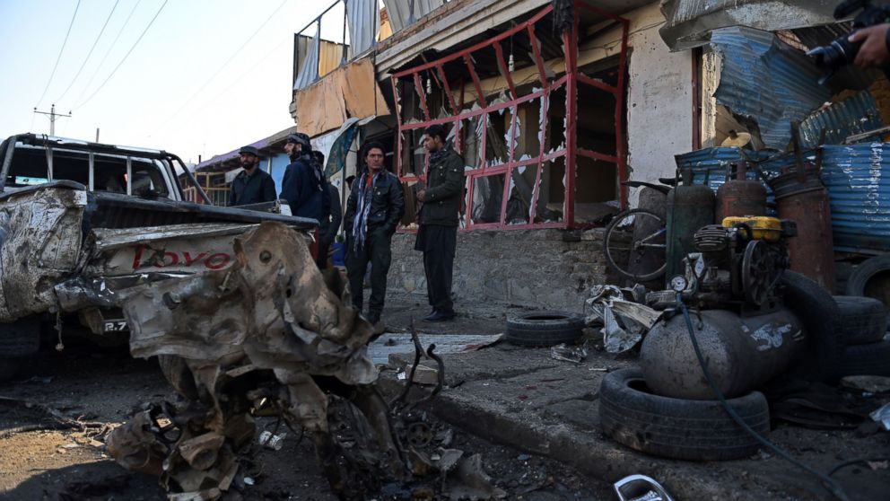 PHOTO:Afghan onlookers stand at the site of a suicide car bomb near the international airport in Kabul, Dec. 28, 2015.   