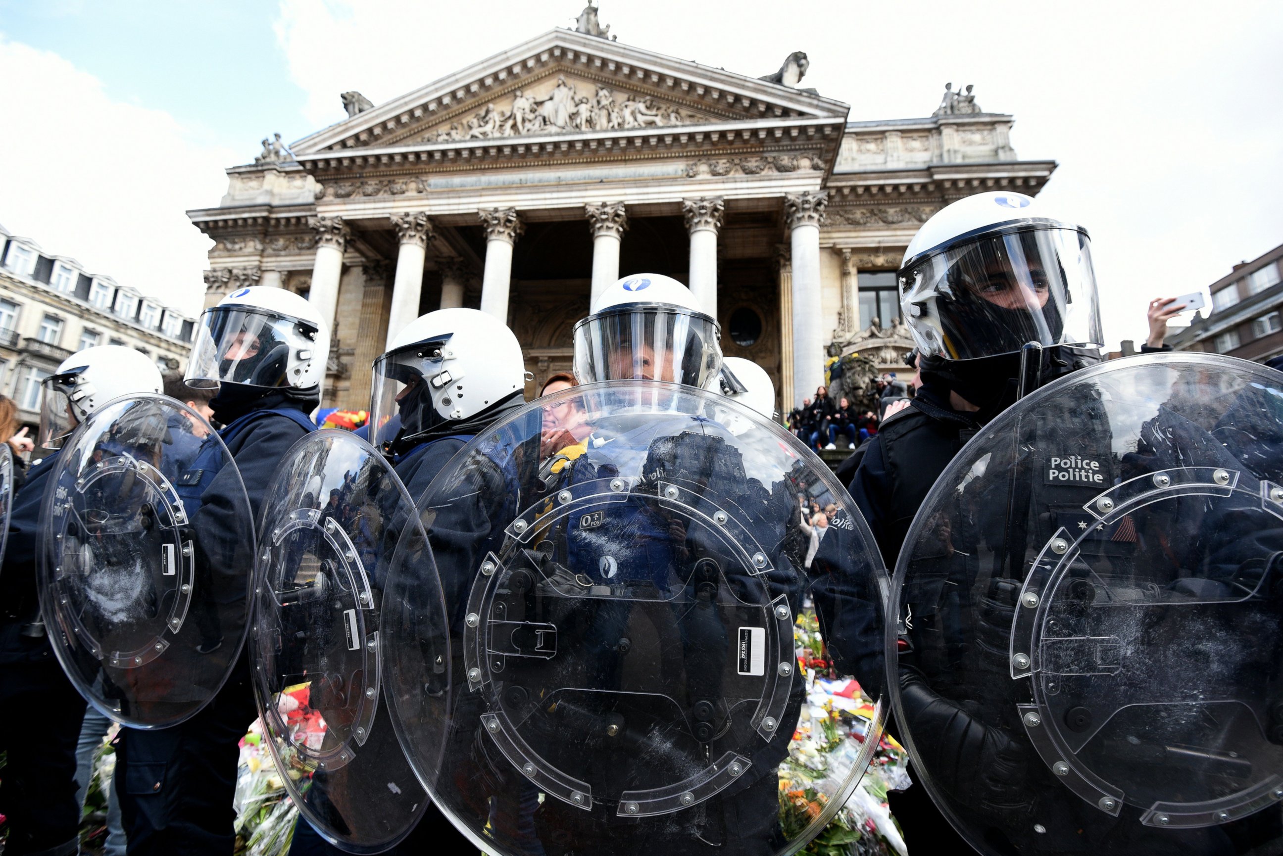 PHOTO: Riot police stand guard as far-right football hooligans disturb the peaceful rally outside the stock exchange, Place de la Bourse square in Brussels, March 27, 2016.