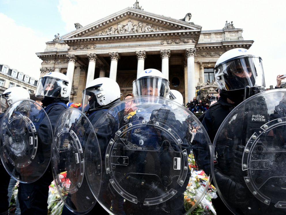 PHOTO: Riot police stand guard as far-right football hooligans disturb the peaceful rally outside the stock exchange, Place de la Bourse square in Brussels, March 27, 2016.