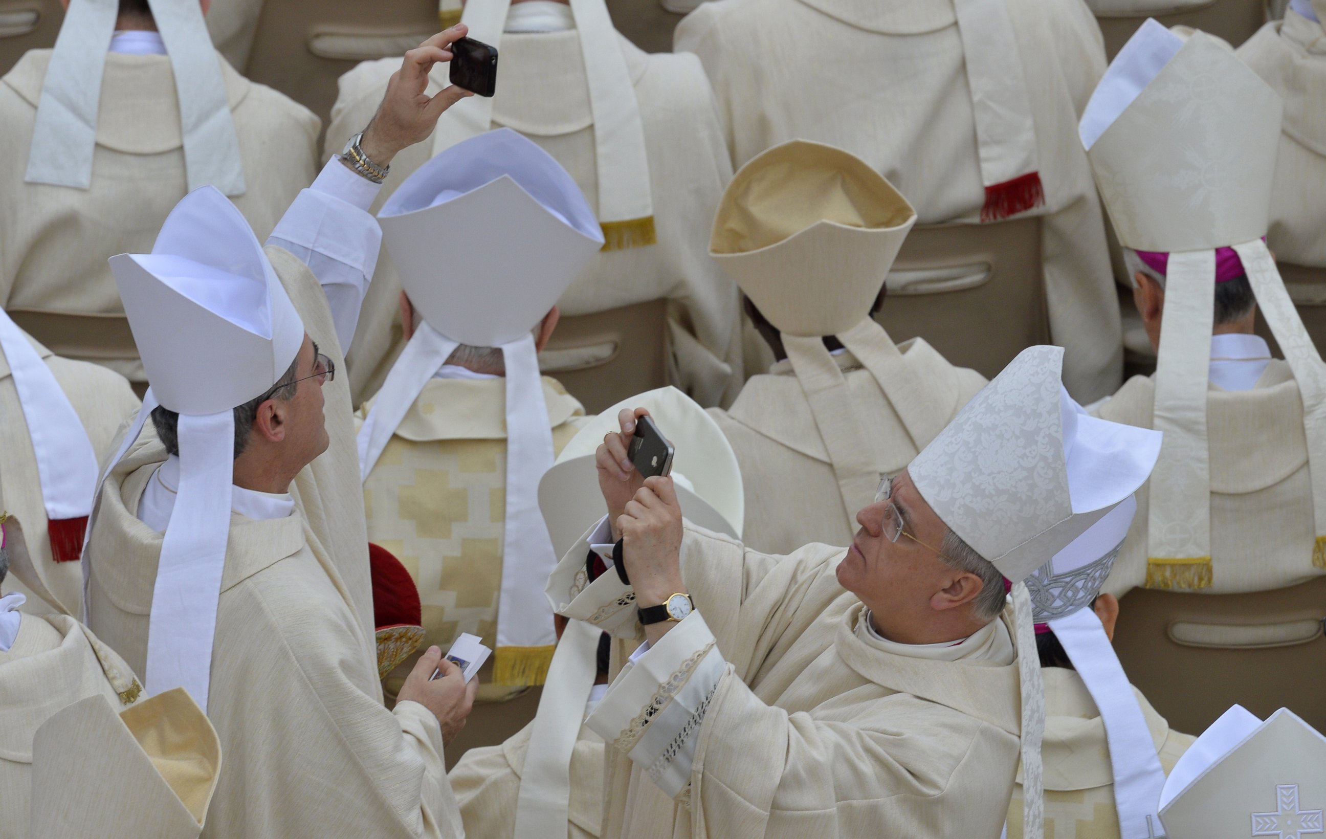 PHOTO: Bishops take pictures before the canonization mass of Popes John XXIII and John Paul II on St Peter's at the Vatican on April 27, 2014. 