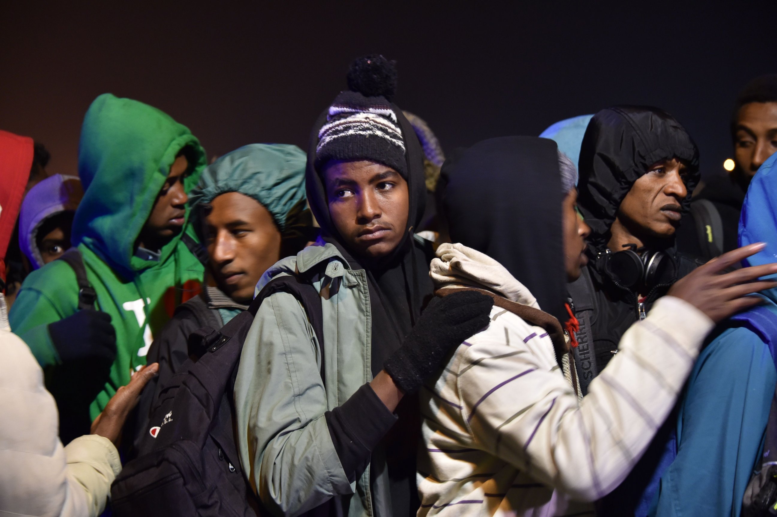 PHOTO: Migrants line up for transportation by bus to reception centers across France, from the "Jungle" migrant camp in Calais, northern France, Oct. 24, 2016.