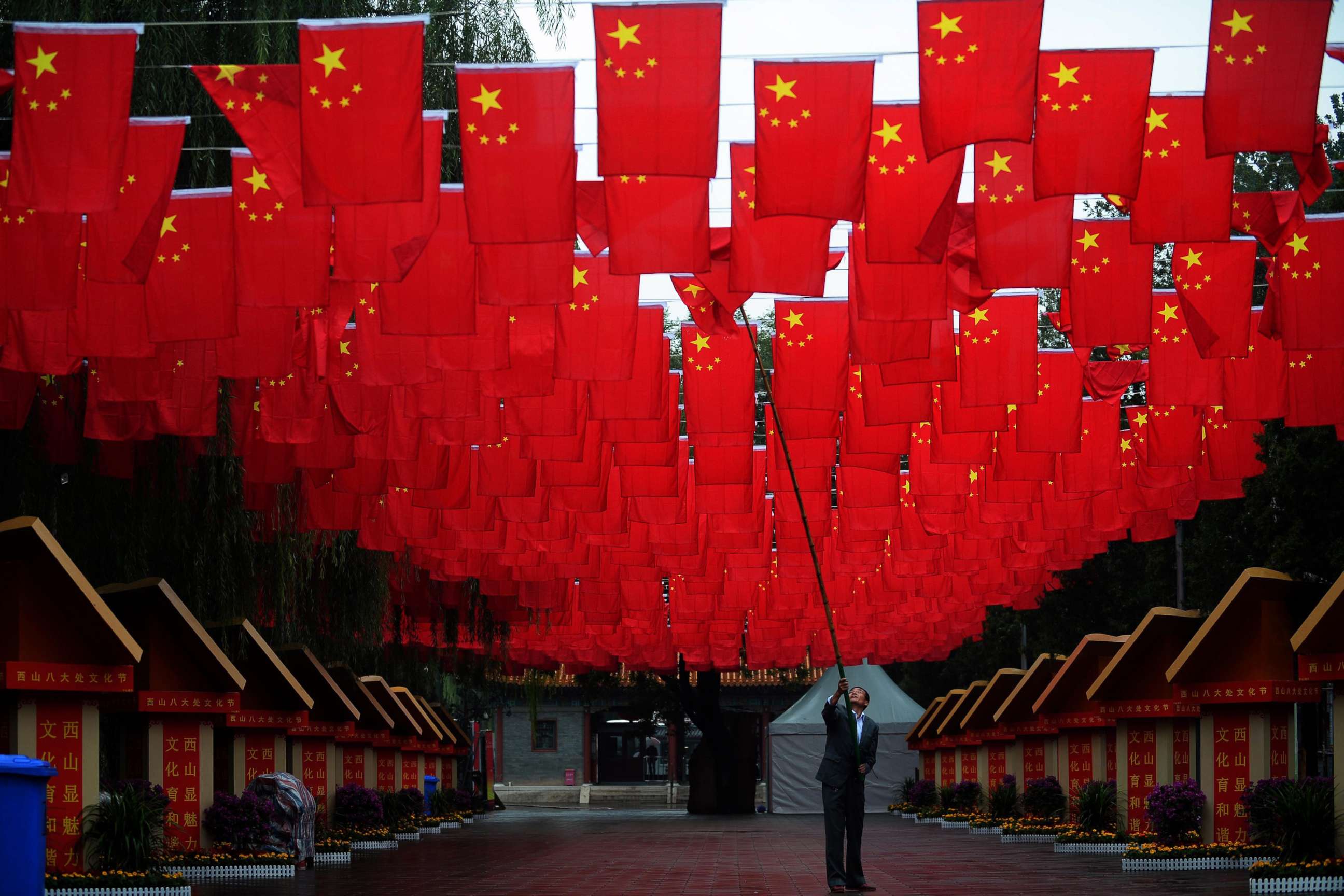 PHOTO: A worker in Beijing adjusts Chinese national flags, Sept 29, 2015, ahead of Chinese National Day.