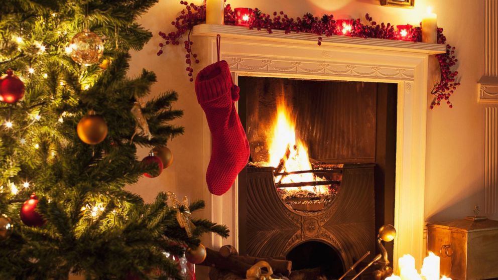 Christmas tree and stocking near fireplace.