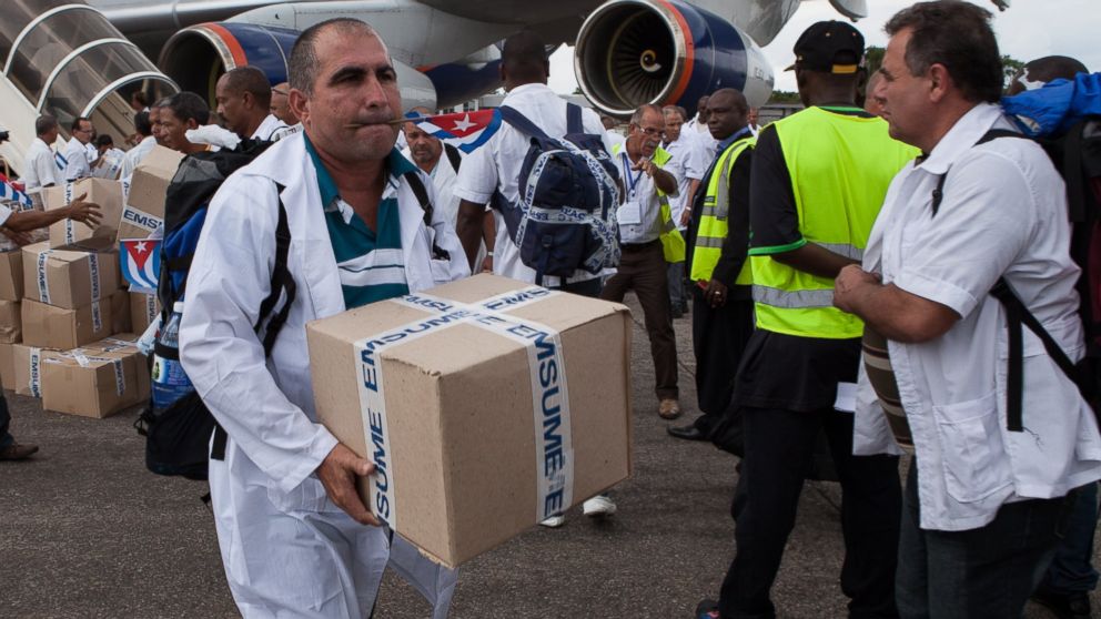 The first members of a team of 165 Cuban doctors and health workers unload boxes of medicine and medical materials from a plane in Sierra Leone on Oct. 2, 2014. 