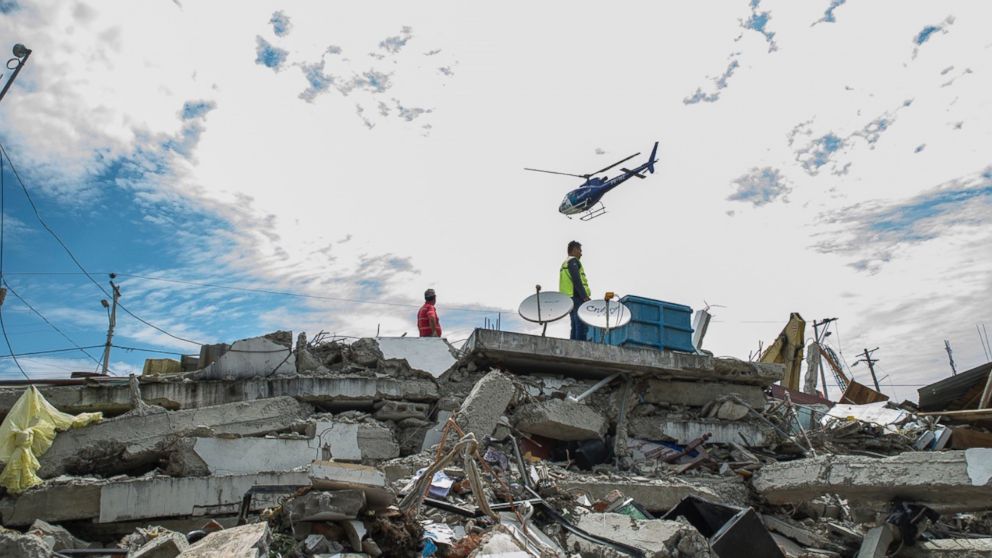 Search and rescue workers are seen on duty over the collapsed buildings in Pedernales, Manabi Province of Ecuador, April 17, 2016. 