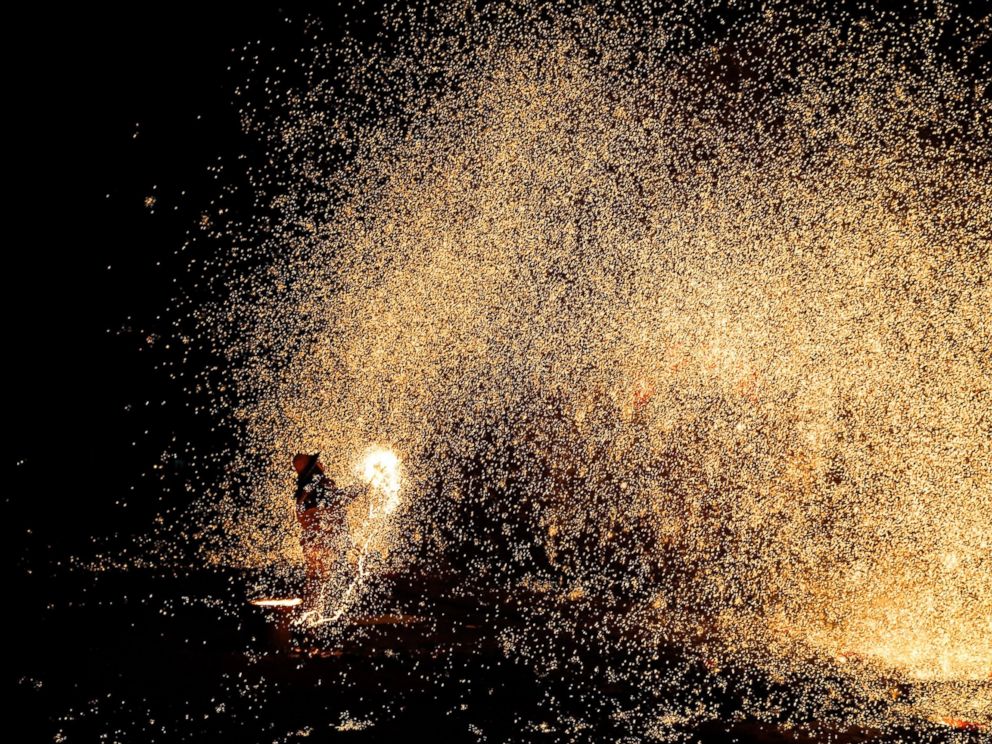 PHOTO: Chinese blacksmiths man a furnace as they prepare to throw the molten metal against a cold stone wall to create sparks, Feb. 23, 2015 in Nuanquan, Hebei Province, China.