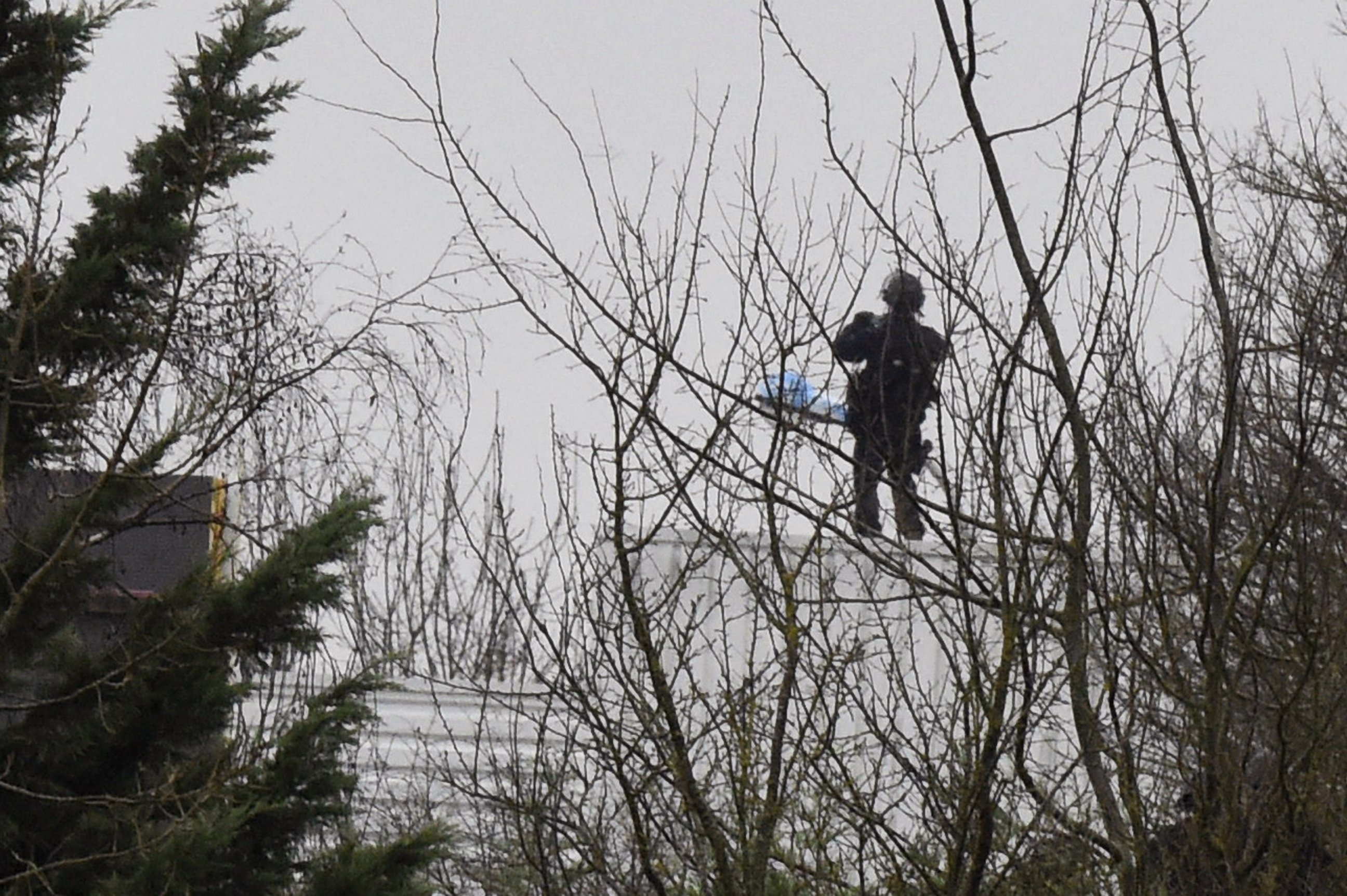 PHOTO: A French police officer stands on the roof  where two suspects in a France massacre  are believed to be holed up, Jan. 9 ,2015, in the village of Dammartin-en-Goele, Northeast of Paris.
