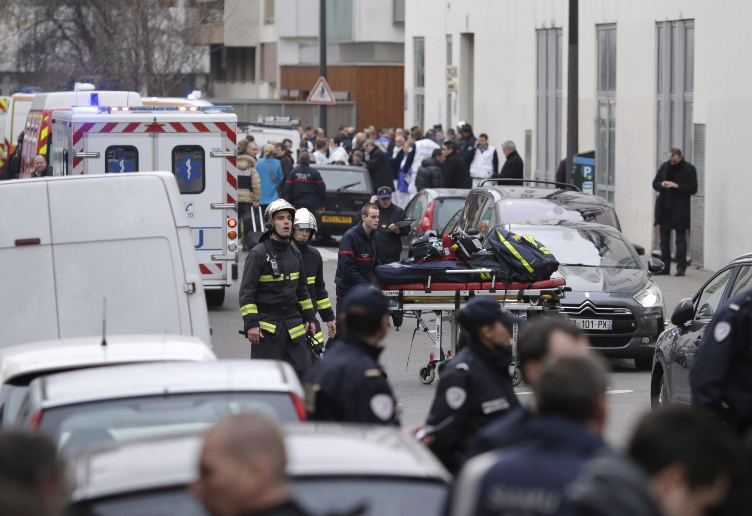 PHOTO: Firefighters push a stretcher outside the headquarters of the French satirical newspaper Charlie Hebdo in Paris on Jan. 7, 2015.