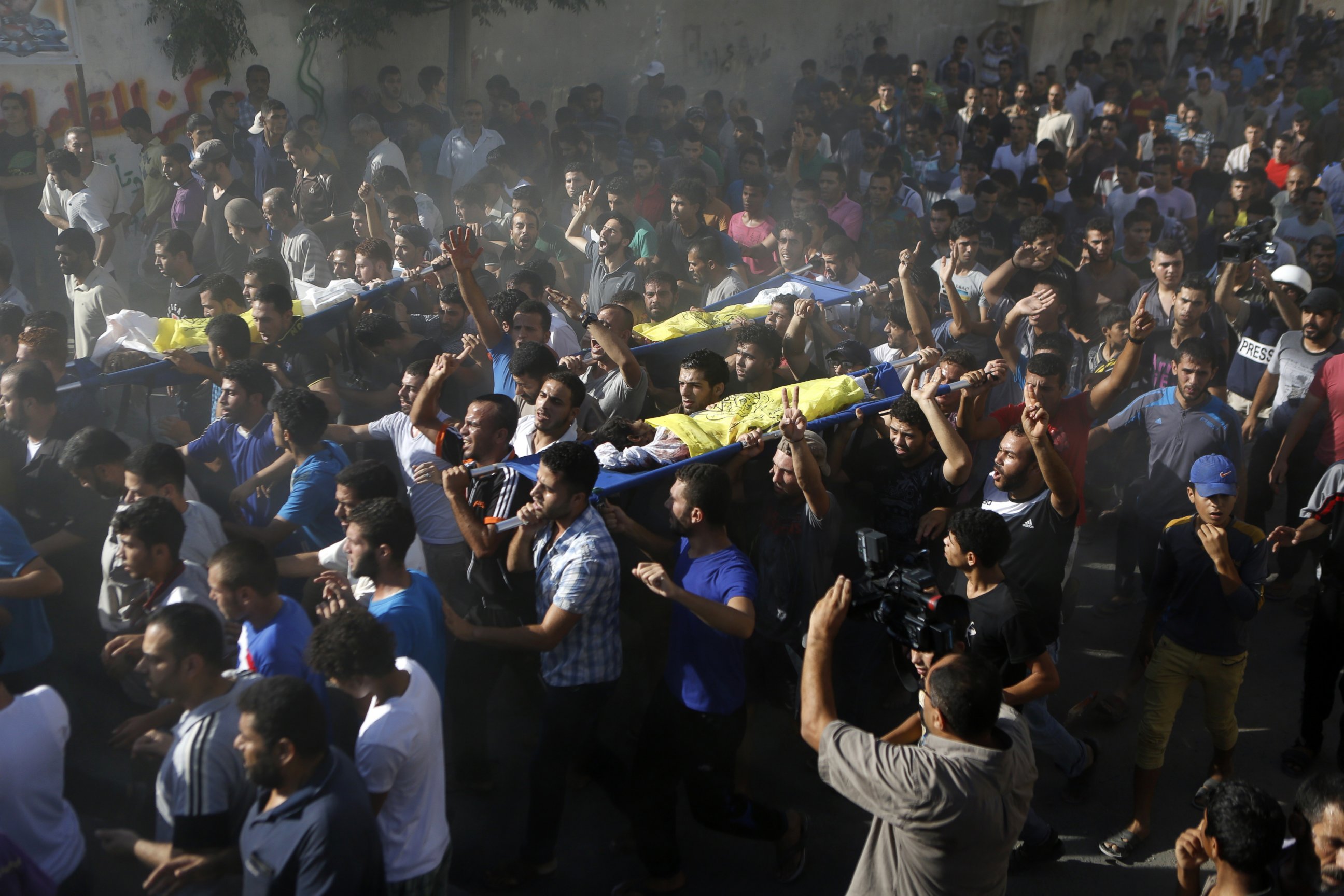 PHOTO: Palestinian mourners shout slogans during the funeral of four boys killed in an attack on a beach in Gaza City, July 16, 2014. 