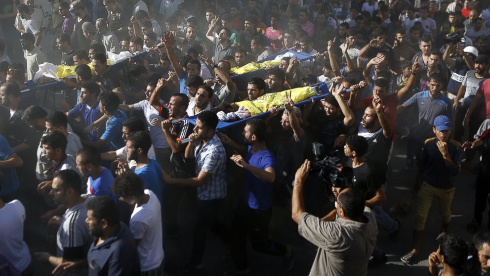 PHOTO: Palestinian mourners shout slogans during the funeral of four boys killed in an attack on a beach in Gaza City, July 16, 2014. 