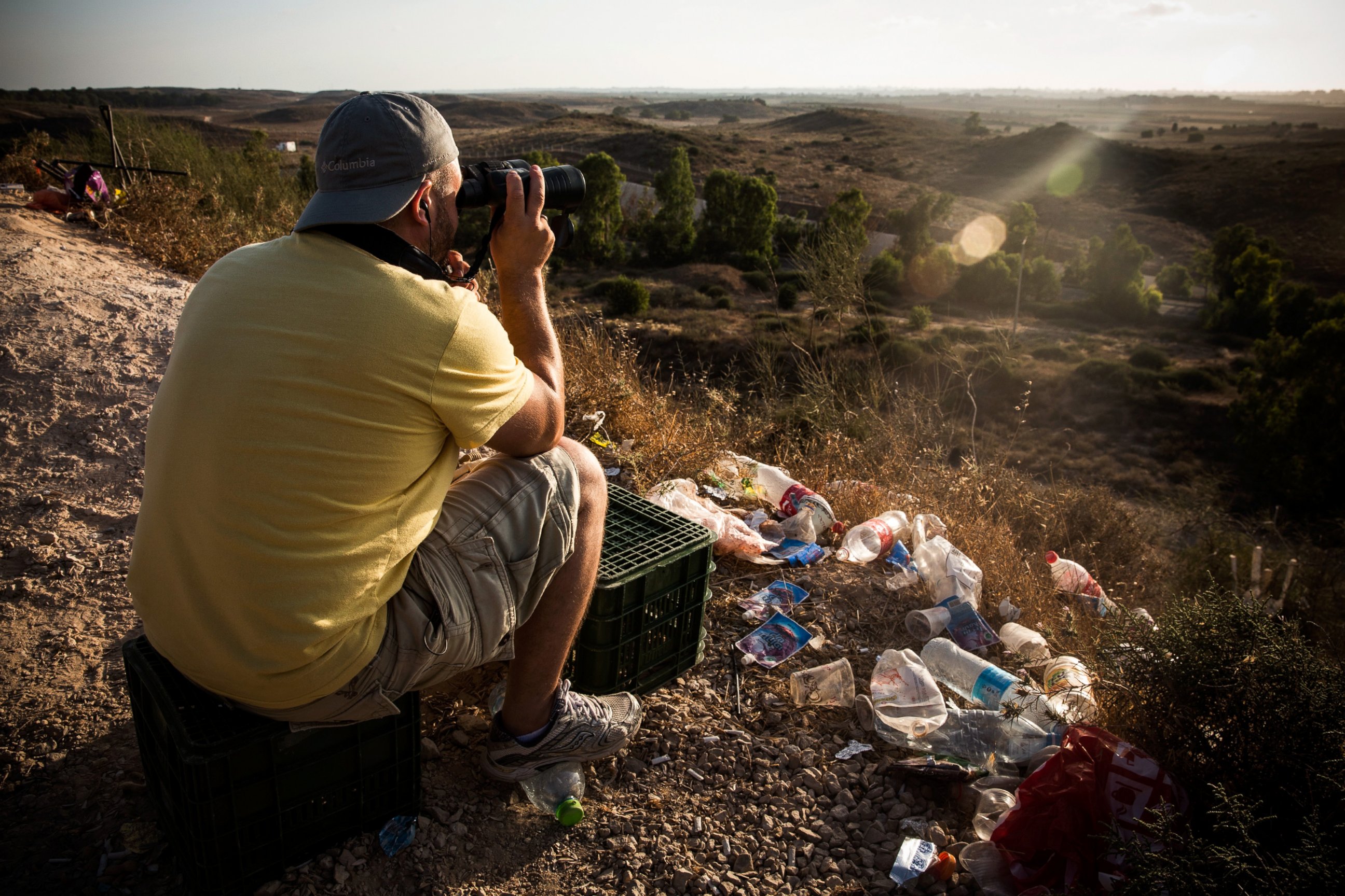 PHOTO: A man uses binoculars while waiting to watch Israeli attacks inside Gaza from the top of a hill on the sixth day of Israel's operation "Protective Edge" on July 13, 2014 in Sderot, Israel. 