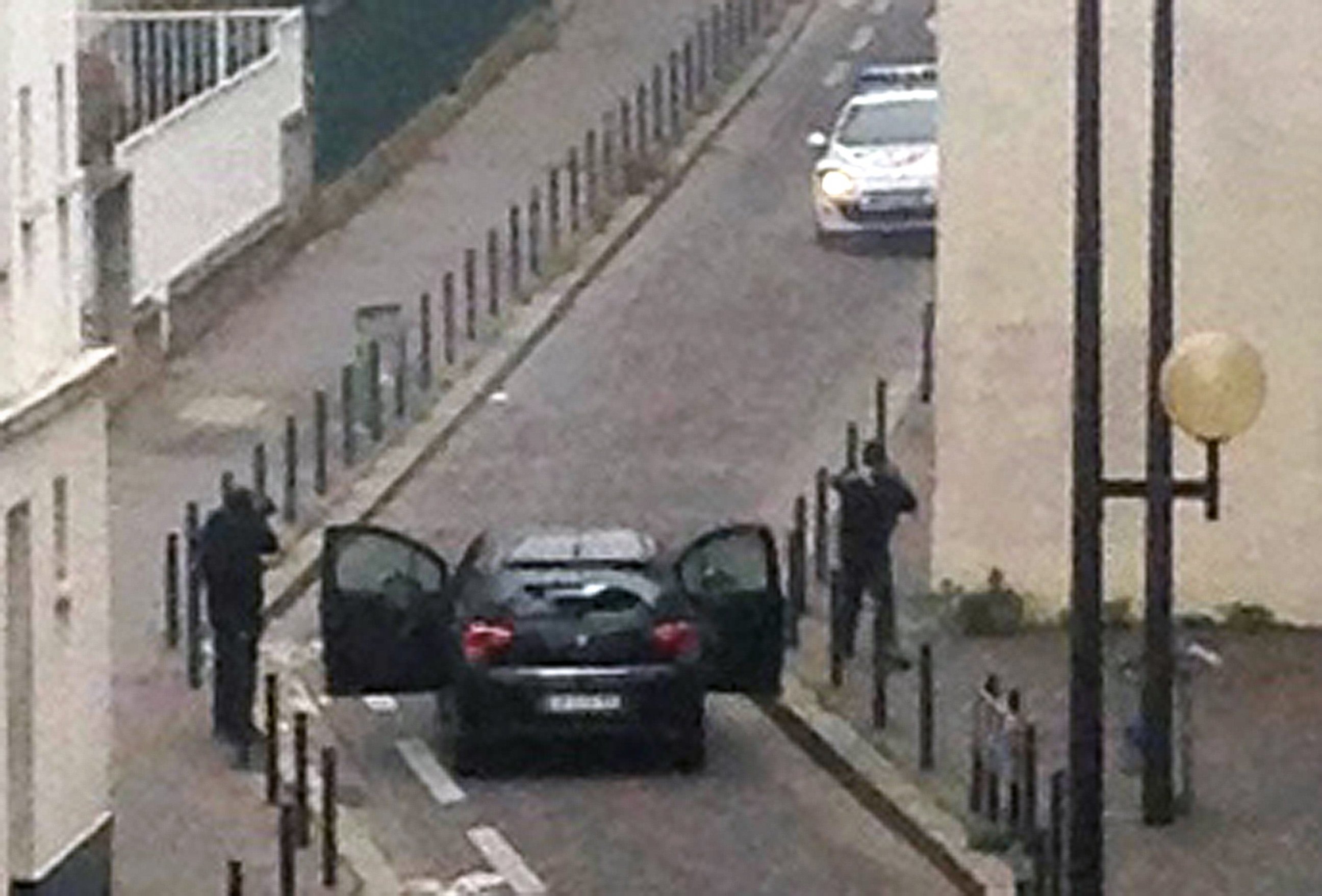 PHOTO: Armed gunmen face police officers near the offices of the French satirical newspaper Charlie Hebdo in Paris on Jan. 7, 2015.