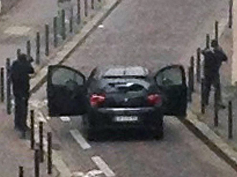 PHOTO: Armed gunmen face police officers near the offices of the French satirical newspaper Charlie Hebdo in Paris on Jan. 7, 2015.