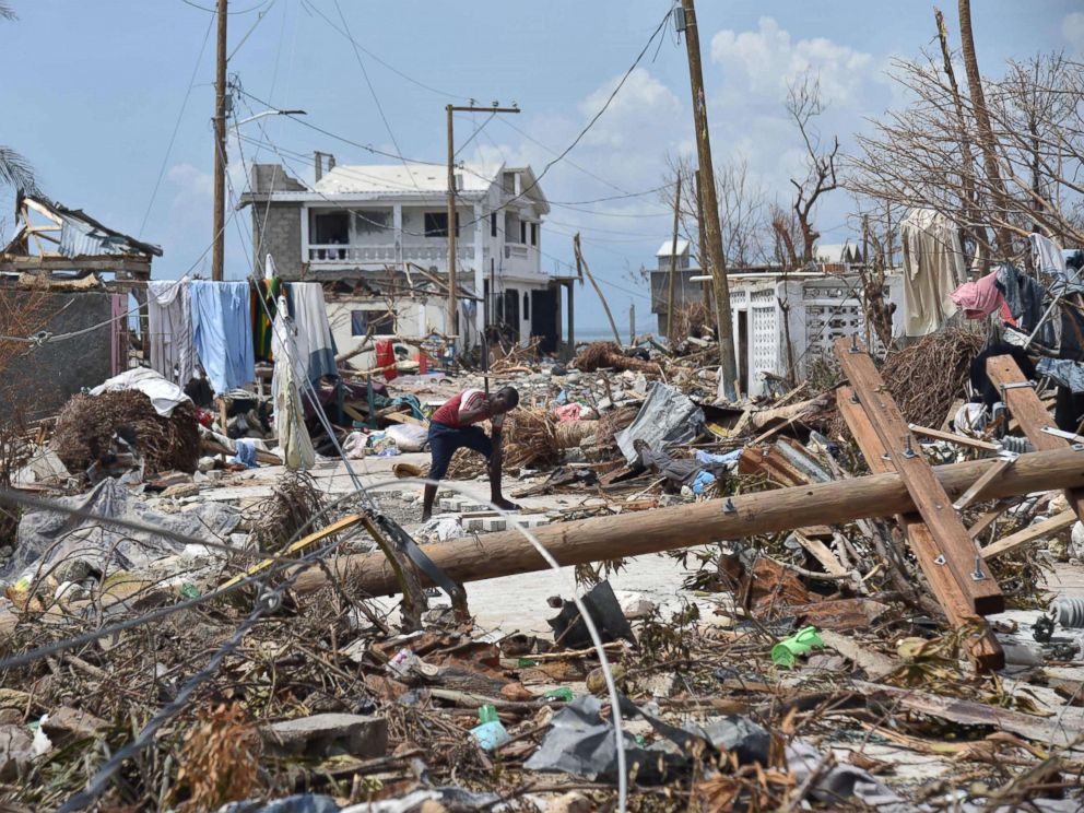 PHOTO: In this file photo, a young man cuts a piece of wood in a street of Les Cayes, Haiti, Oct. 10, 2016, following the passage of Hurricane Matthew.