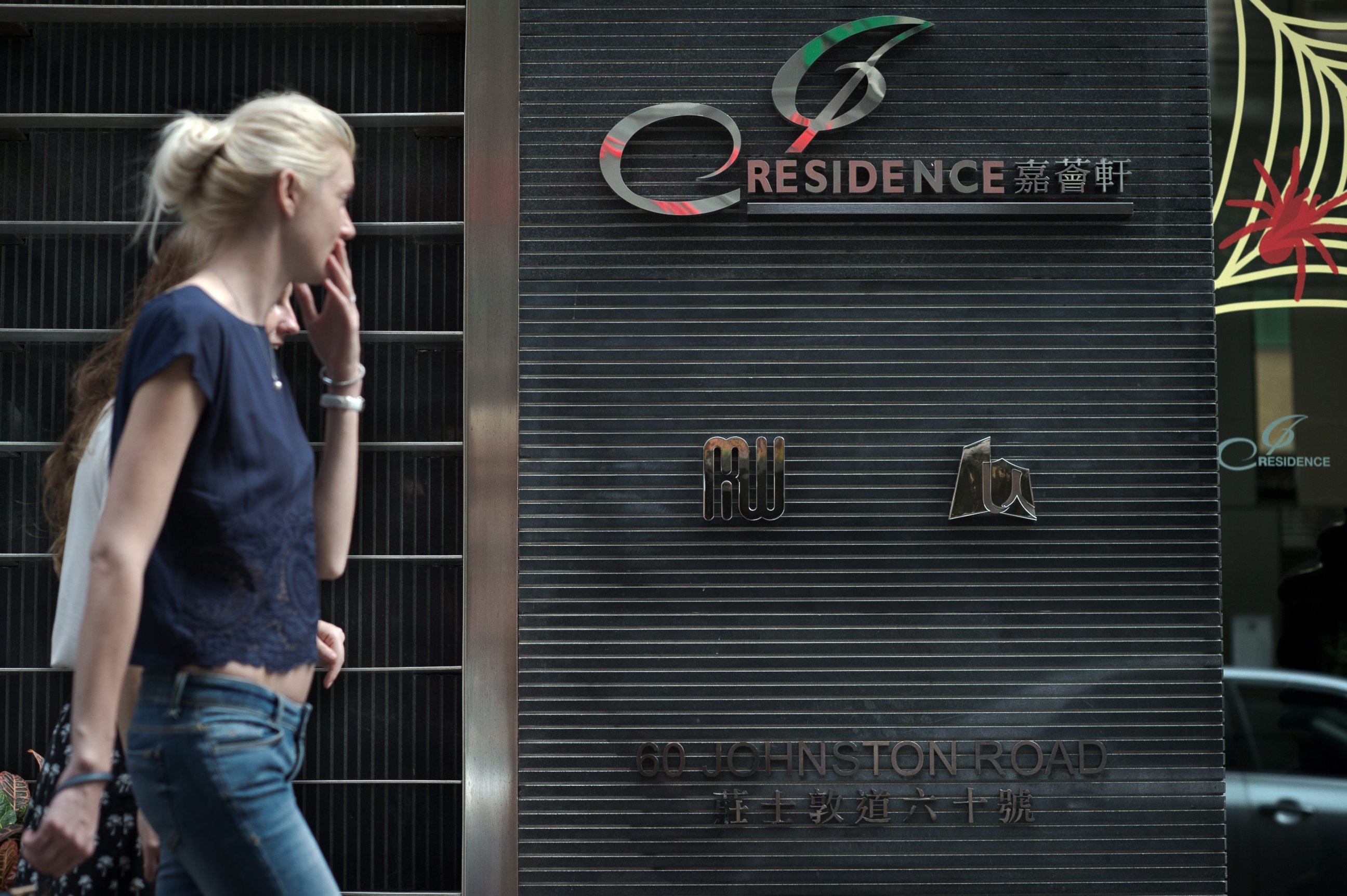 PHOTO: Pedestrians walk in front of the J Residence building front entrance in Hong Kong on Nov. 2, 2014.
