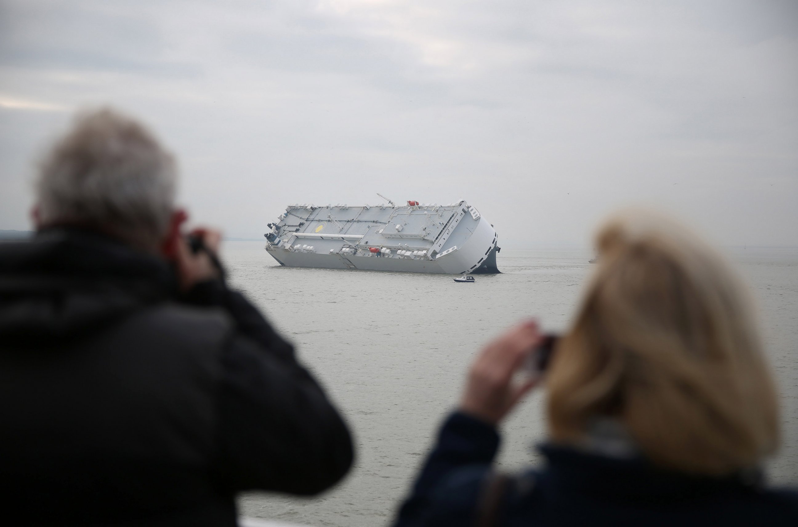 PHOTO: Passengers on a passing car ferry take photographs of the Hoegh Osaka after it ran aground