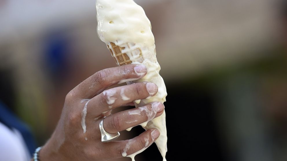 A woman eats melting ice cream on July 2, 2015 in Paris.     