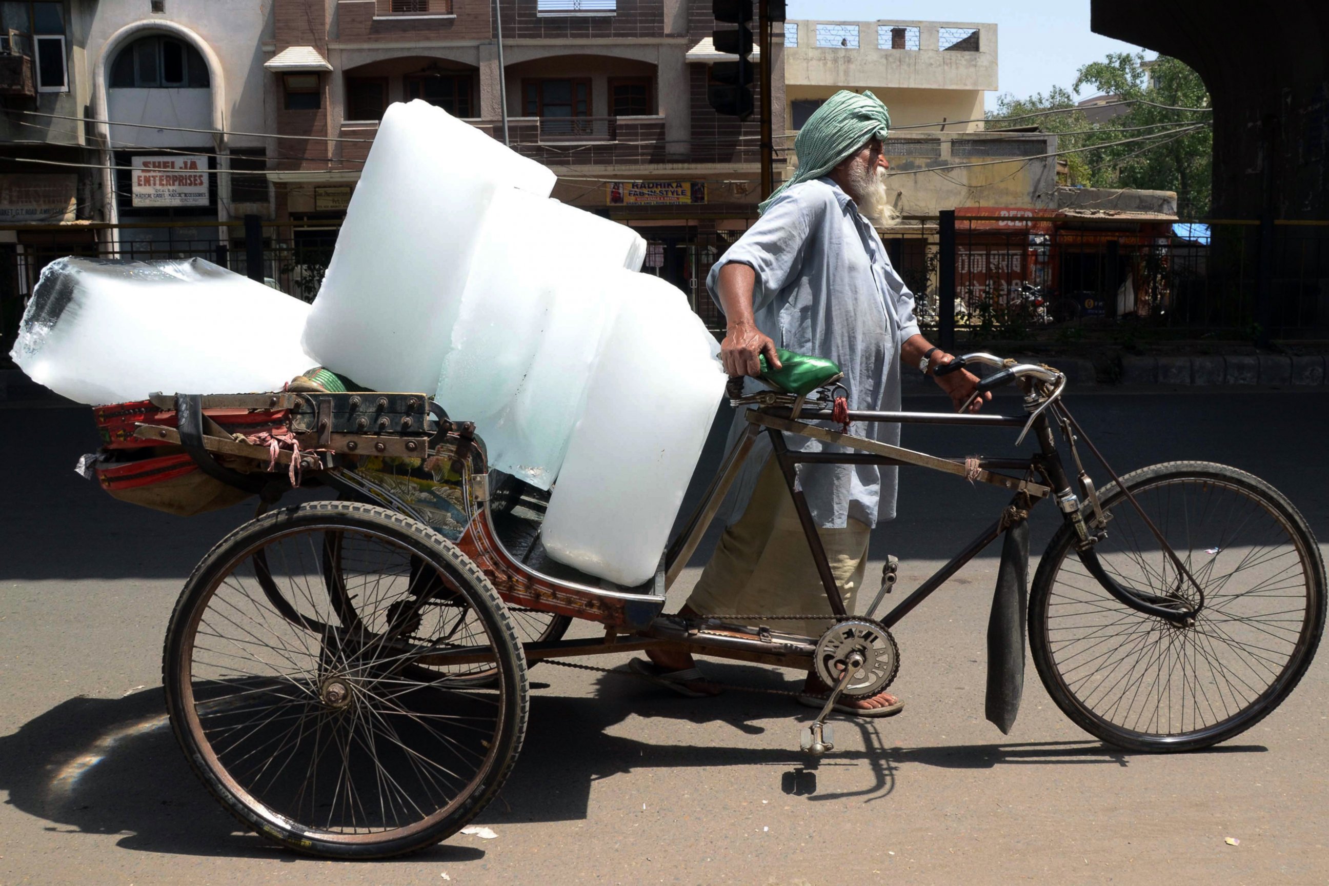 PHOTO: An Indian worker uses a ricksahw to transport ice from an ice factory in Amritsar on May 27, 2015.