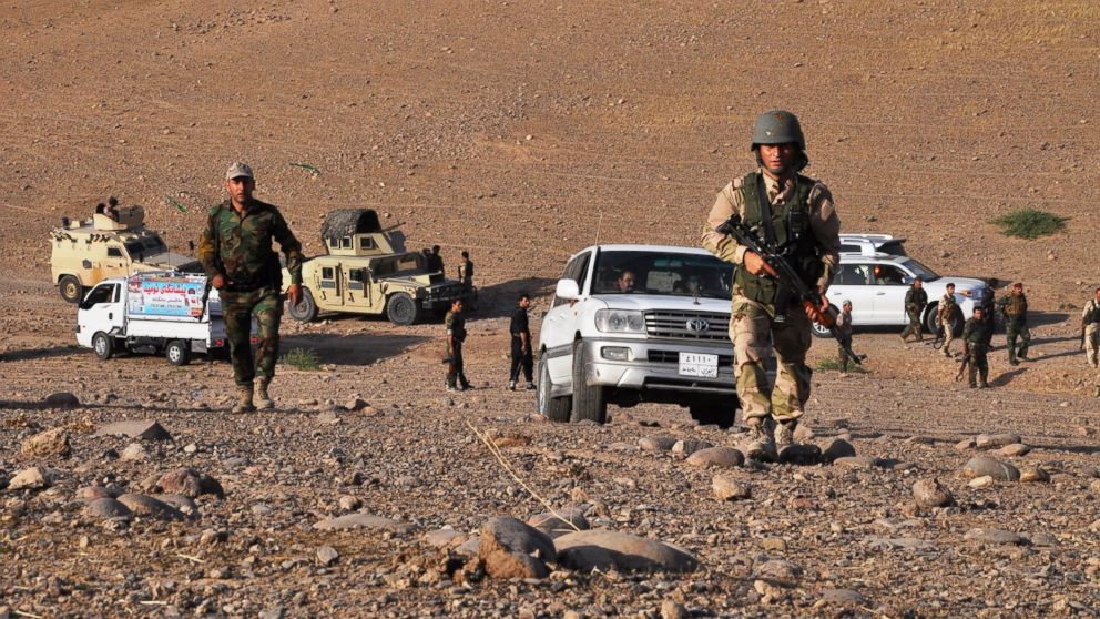 PHOTO: Members of the Kurdish Peshmerga forces take a position to fight 