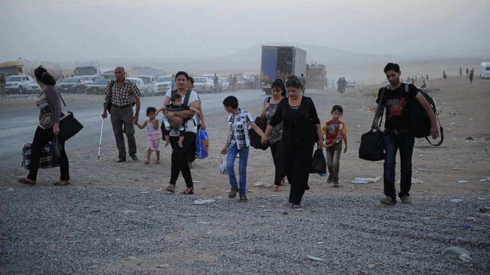 Thousands of Yazidi and Christian people flee Hamdaniyah town for Erbil after the latest wave of ISIL advances has seen a number of towns near Iraq's second largest city Mosul fall to the militants on Aug. 6, 2014. 