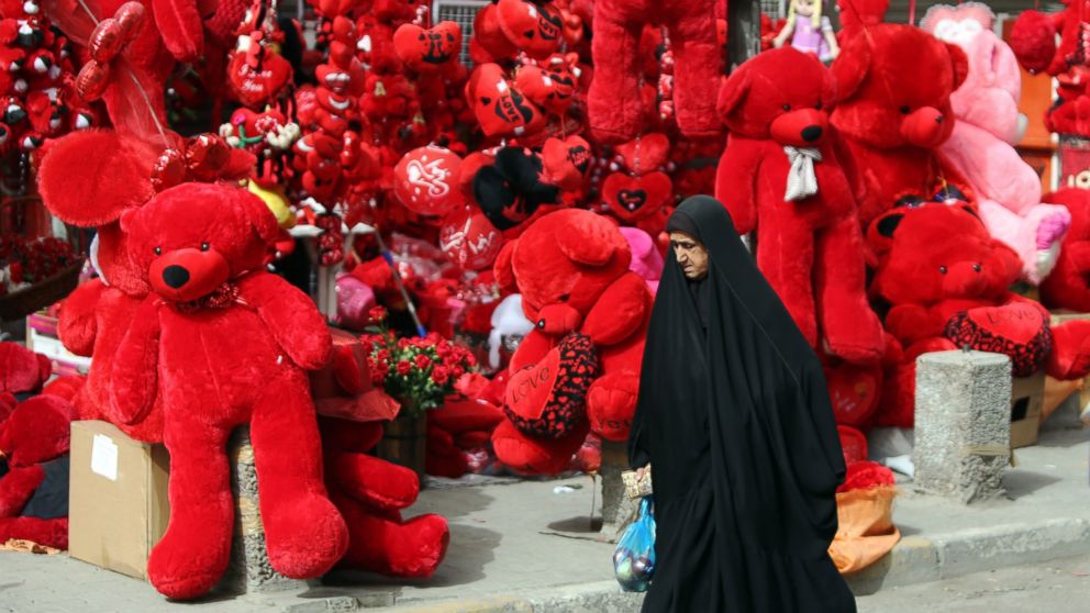 An Iraqi woman walks past a shop displaying red teddy bears in preparation for Valentine's day in Baghdad's Karrada district, Feb. 12, 2015.