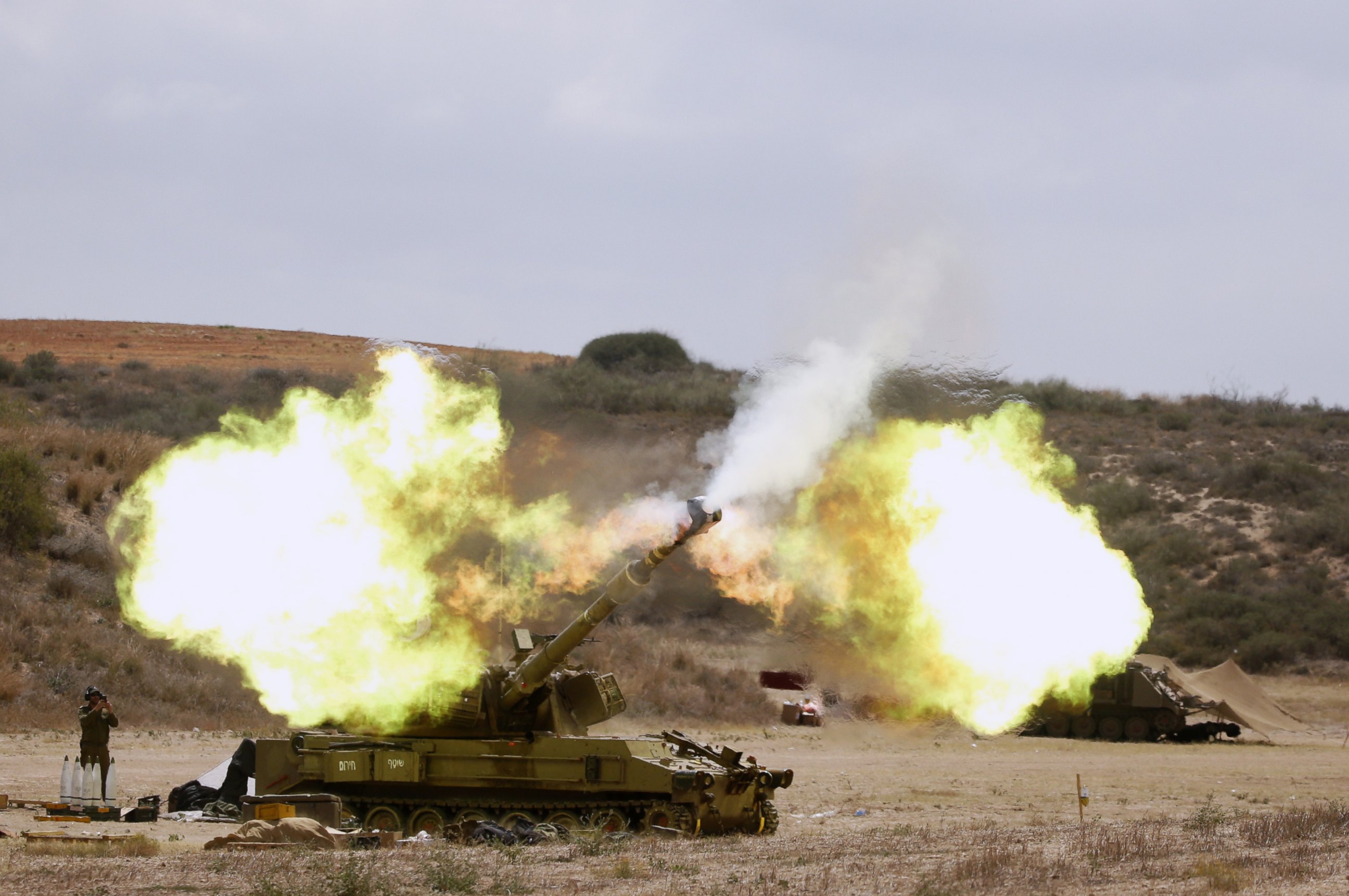 PHOTO: An Israeli army self-propelled howitzer cannon fires a shell from the Israel-Gaza border