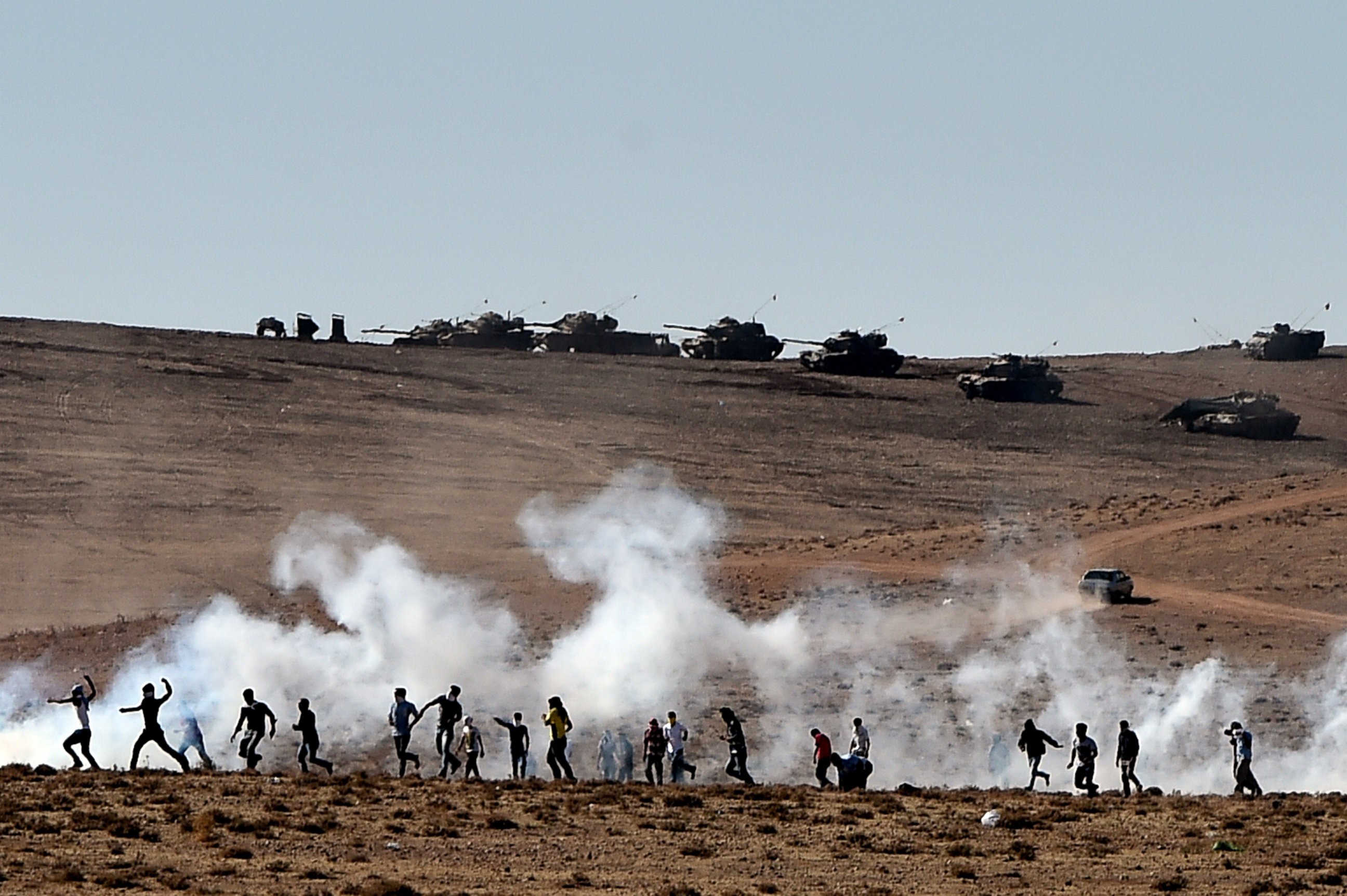 PHOTO: Kurdish people throw stones at Turkish armored vehicles near the Syrian town known as Kobane by the Kurds, in the southeastern town of Suruc, Sanliurfa province, Turkey, Oct. 7, 2014.